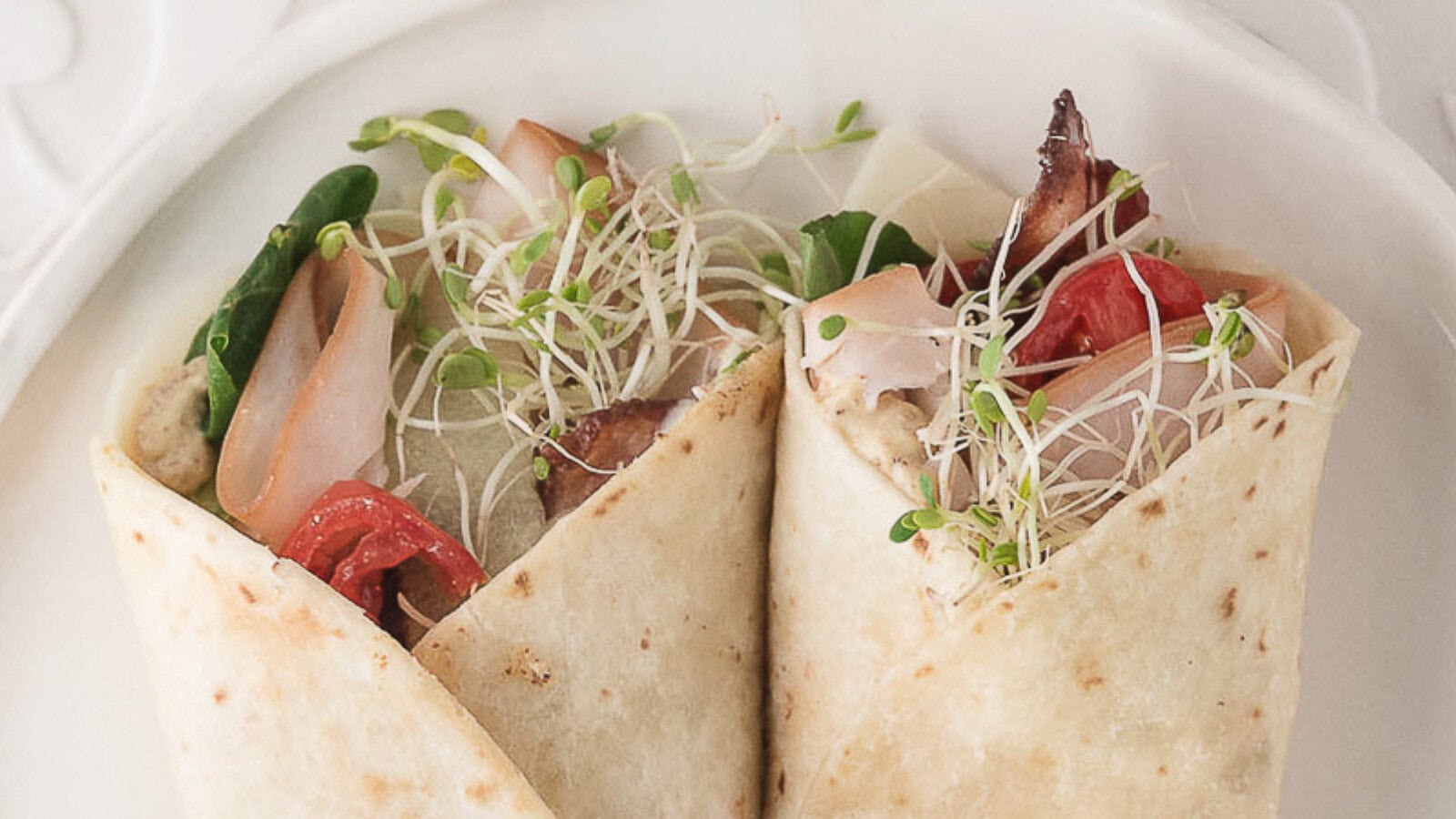 warm turkey bacon wraps on a white plate