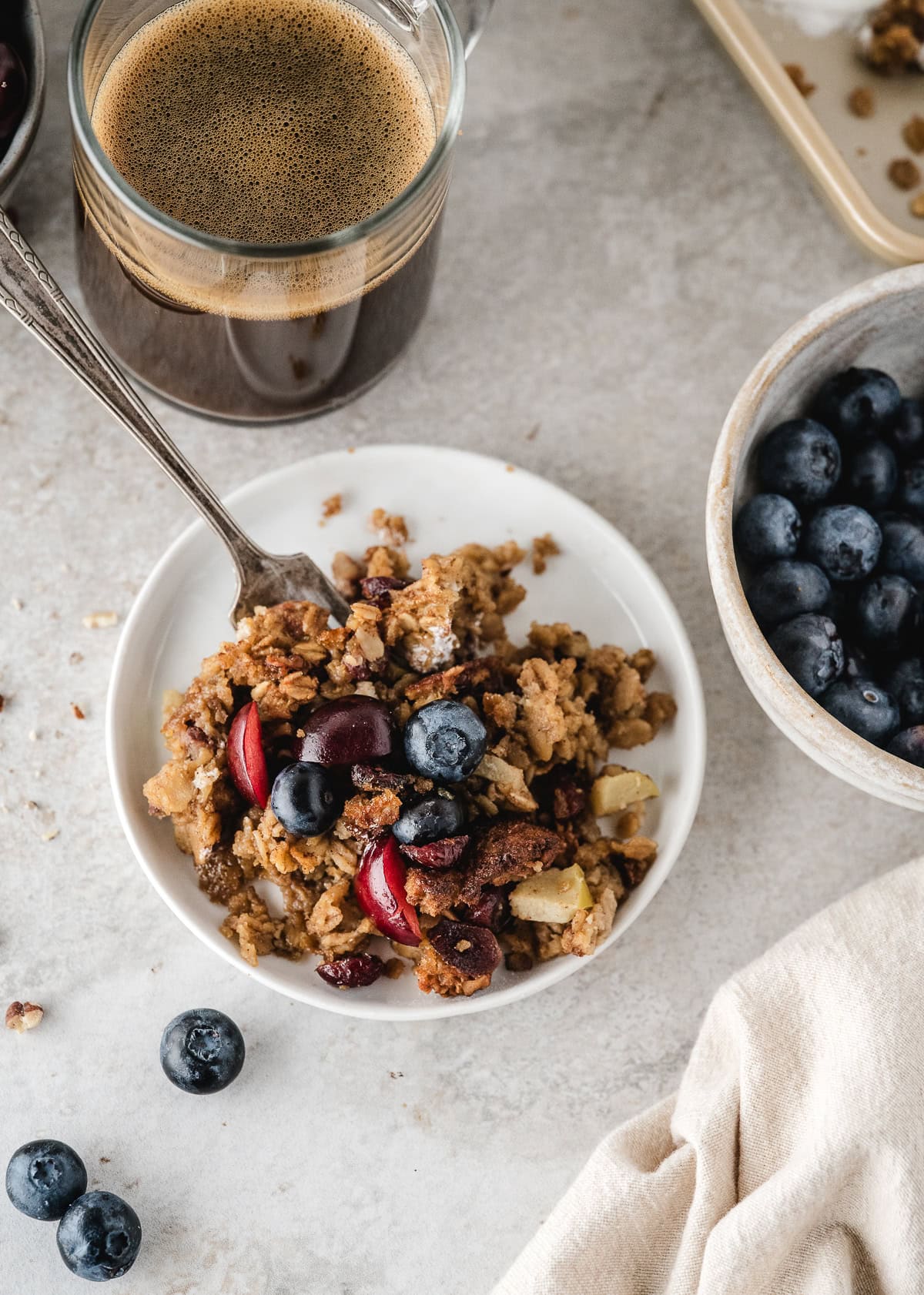 easy baked oatmeal stirred up with cinnamon, apple, blueberry, and cherry