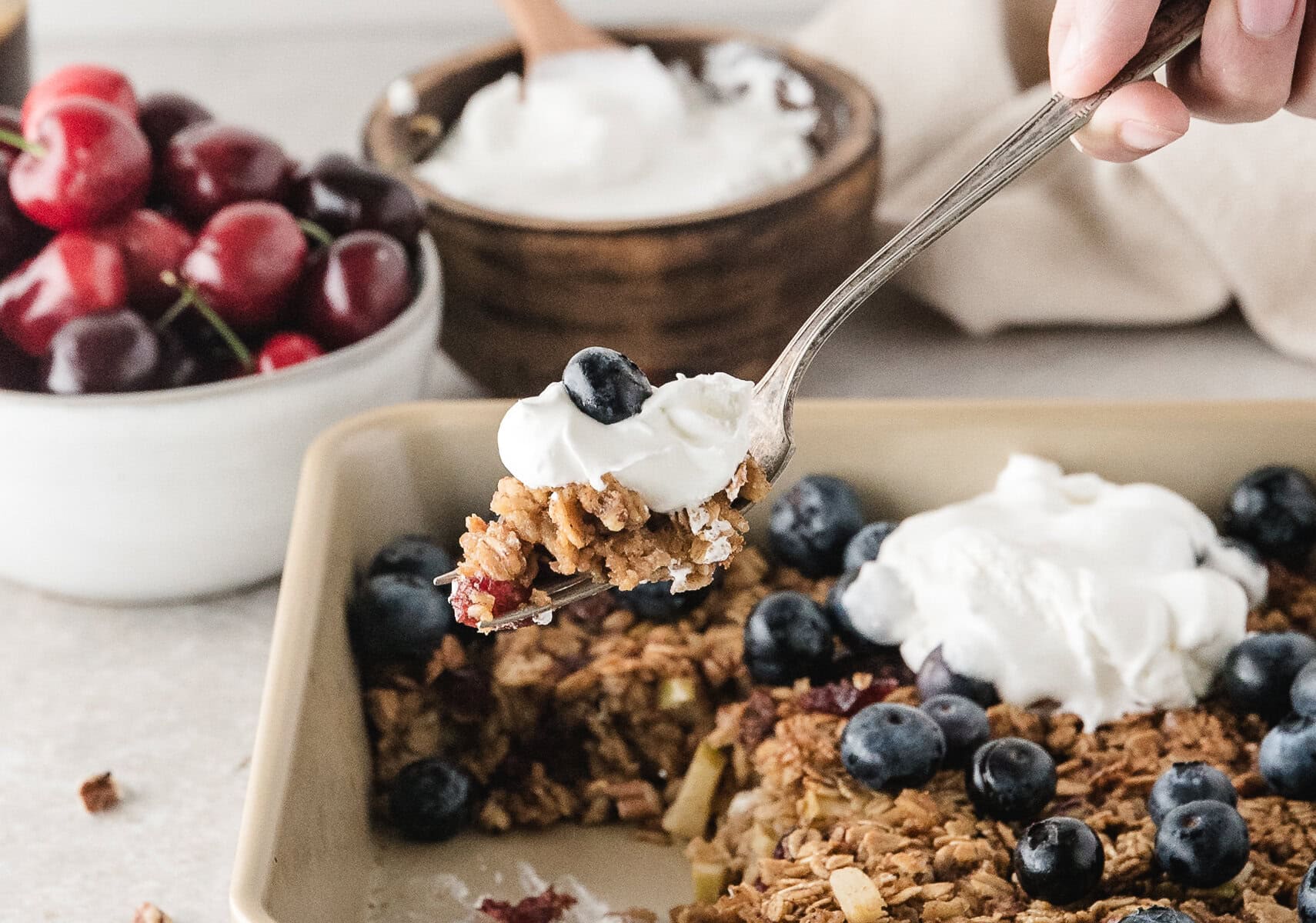 a forkful of healthy baked oatmeal topped with whipped topping and blueberry