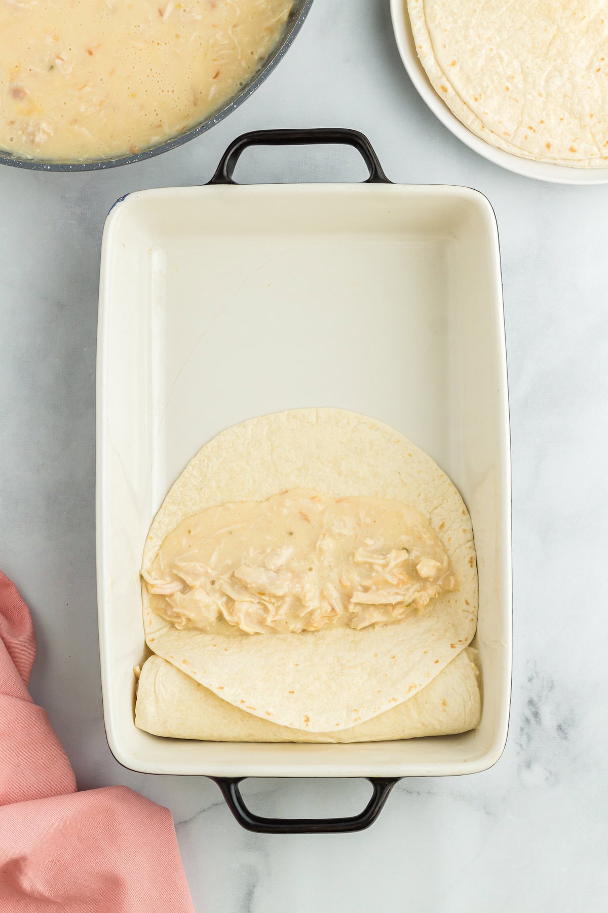 add a third cup of filling to the center of a tortilla in the baking dish
