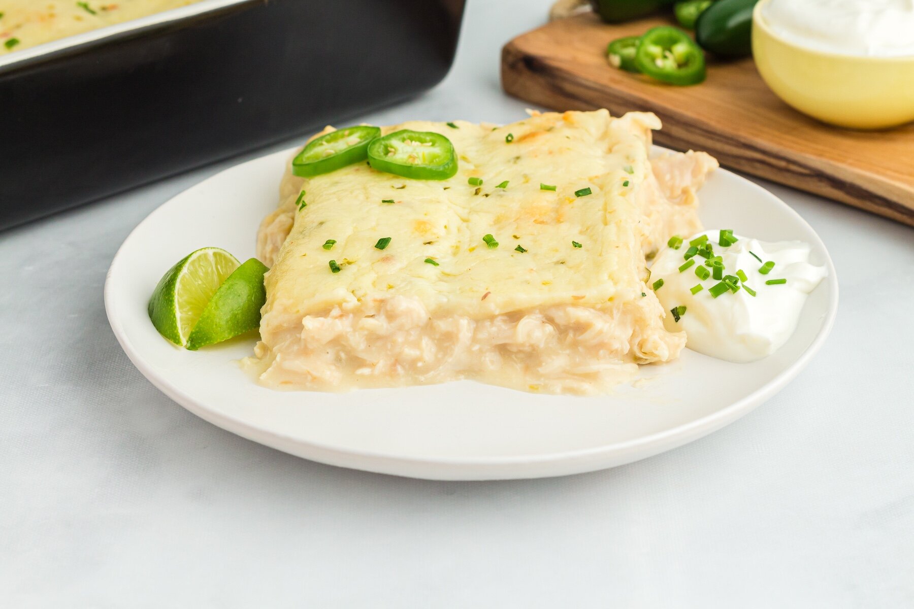 two Creamy White Chicken Enchiladas viewed from the side, showing their Cream of Chicken filling