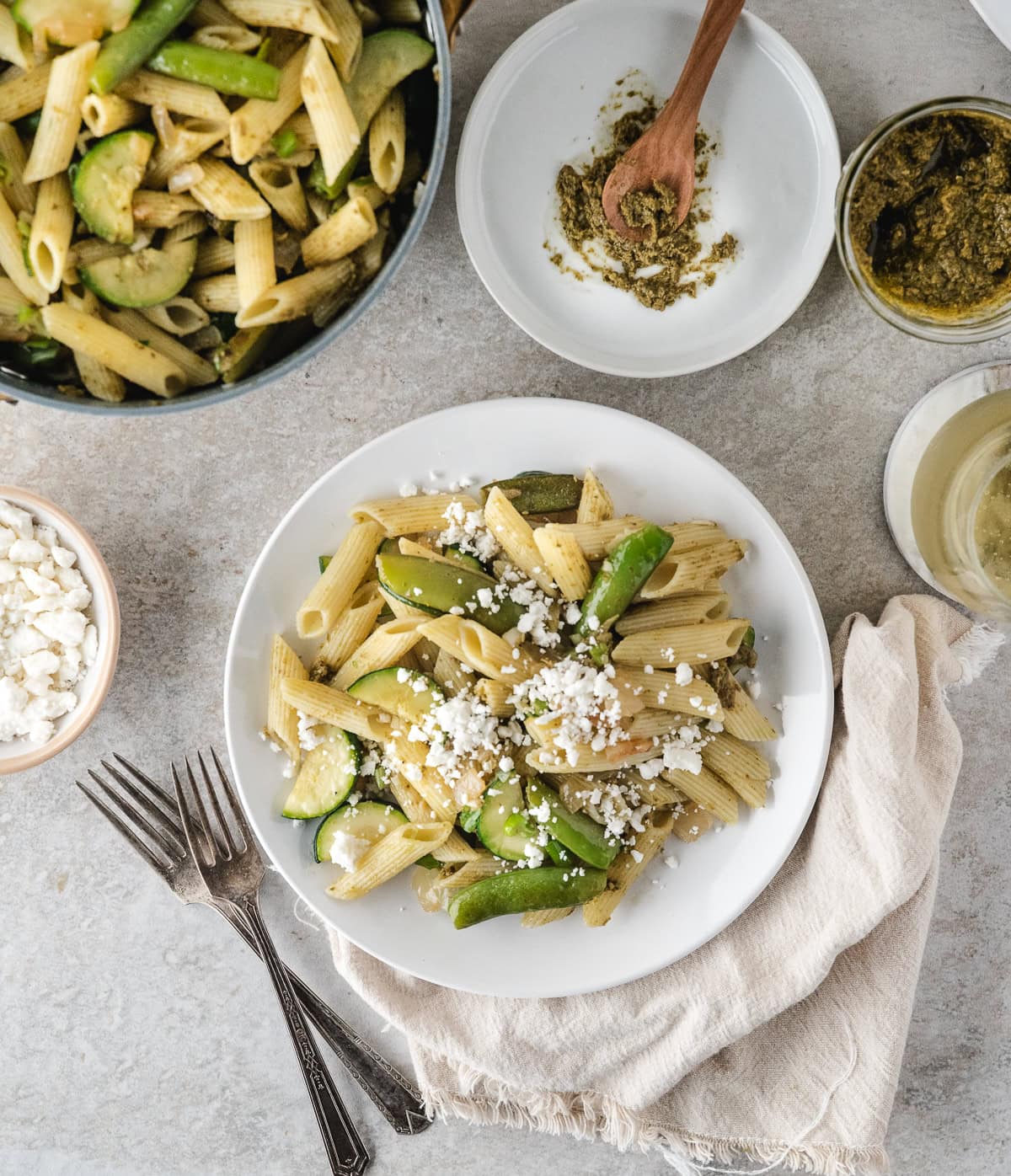 one serving of pesto pasta primavera topped with feta cheese
