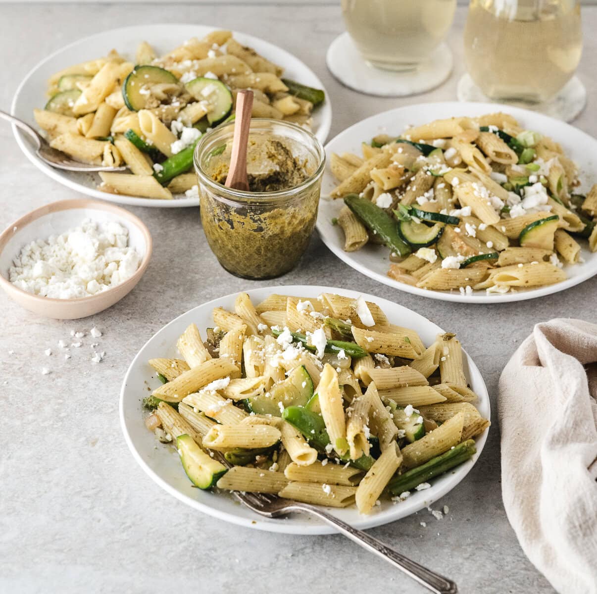 three plates of easy pasta primavera with pesto and feta cheese