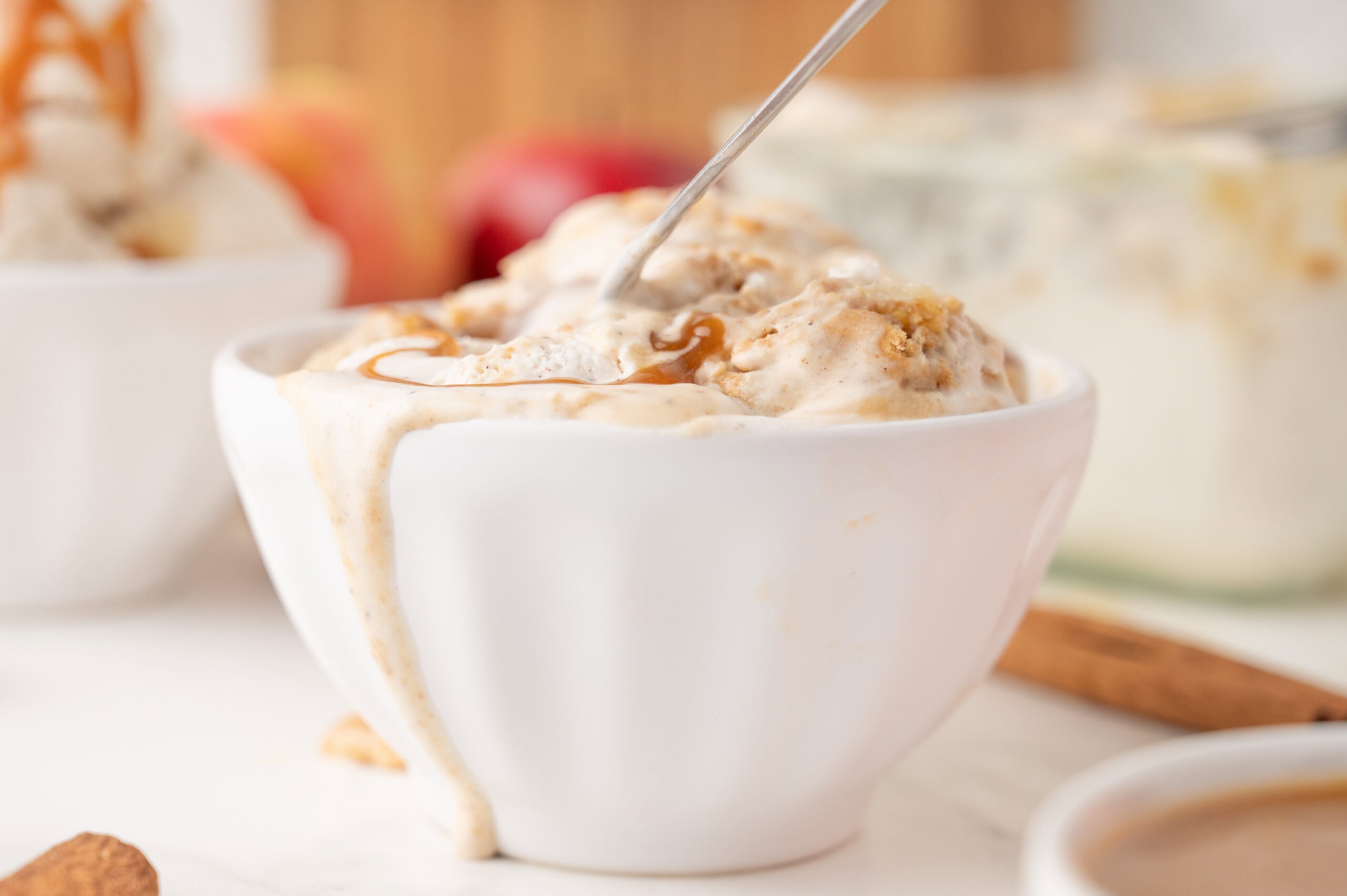 Apple pie ice cream served in a bowl with caramel sauce