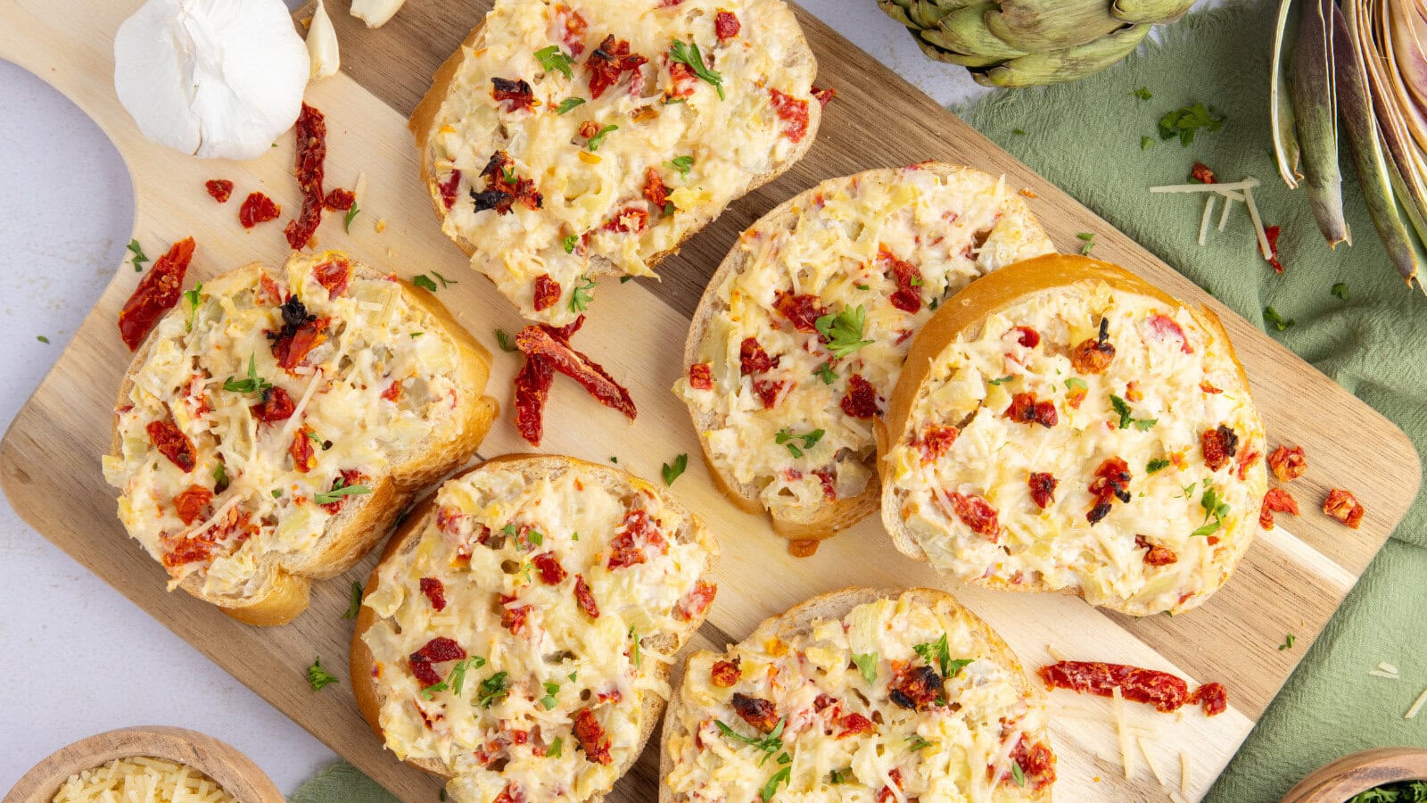 six slices of Artichoke Bruschetta with Sun-Dried Tomatoes on a cutting board