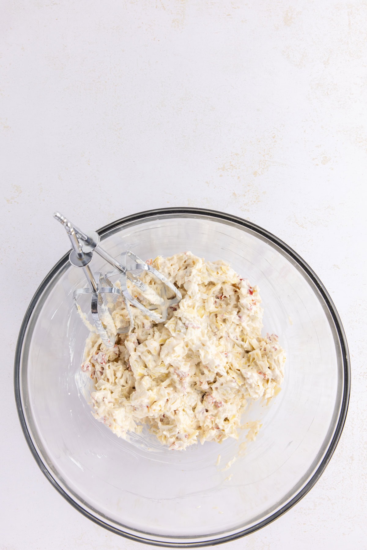 mix the artichokes, cheeses, and sun-dried tomatoes with an electric mixer