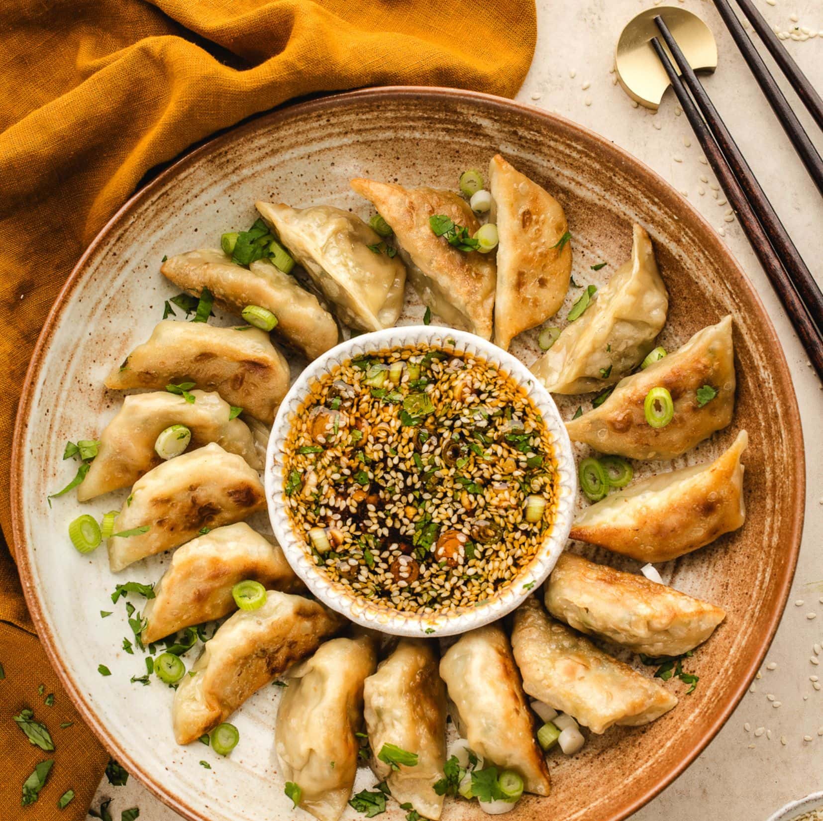 Dumplings are air fried and ready to be served. All on a platter with dipping sauce in the middle