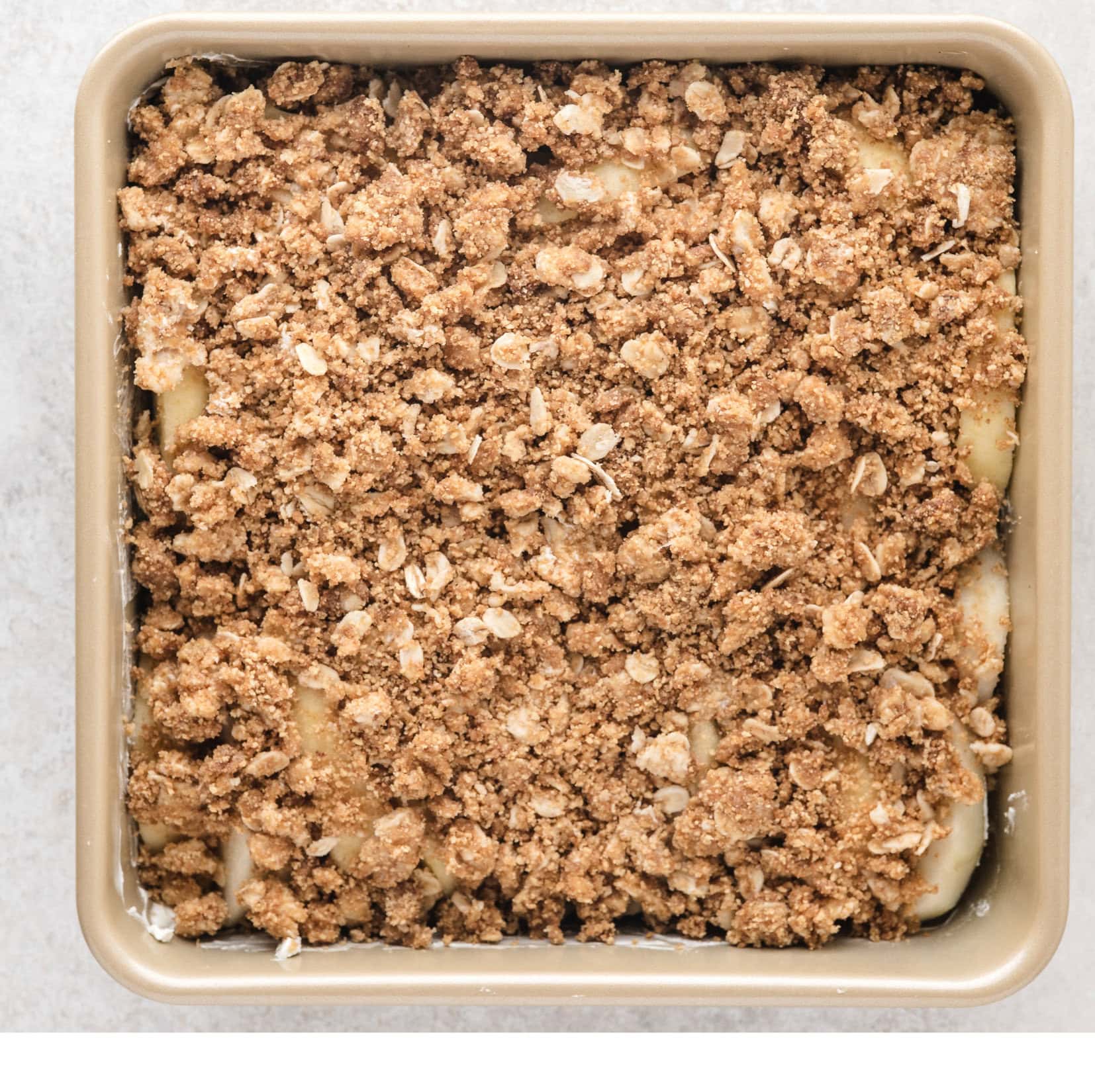 the apple crisp with oats and graham cracker is all prepared in pan ready to be baked