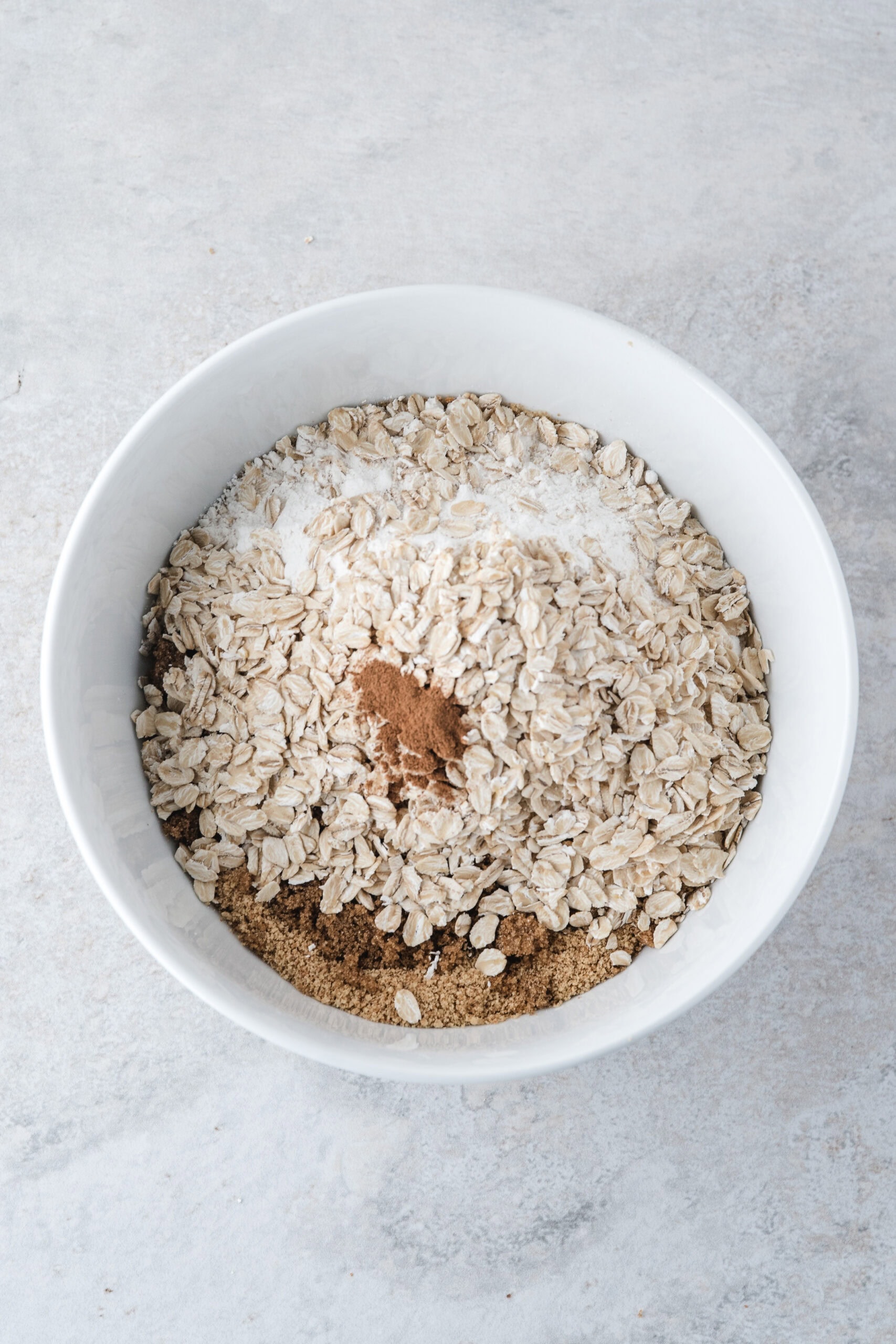 in this apple crisp recipe with oats and graham crackers all the dry ingredients are mixed together in the bowl ready to be stirred all together