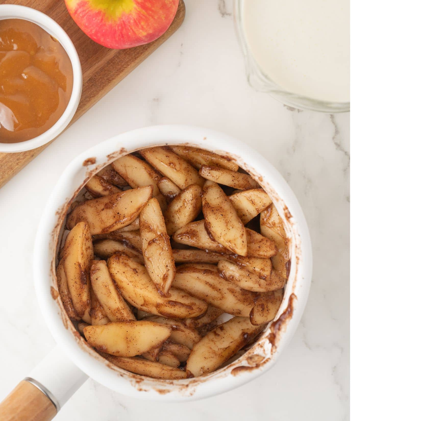 Cinnamon tossed and evenly coated on peeled and cored apples to create apple pie ice cream