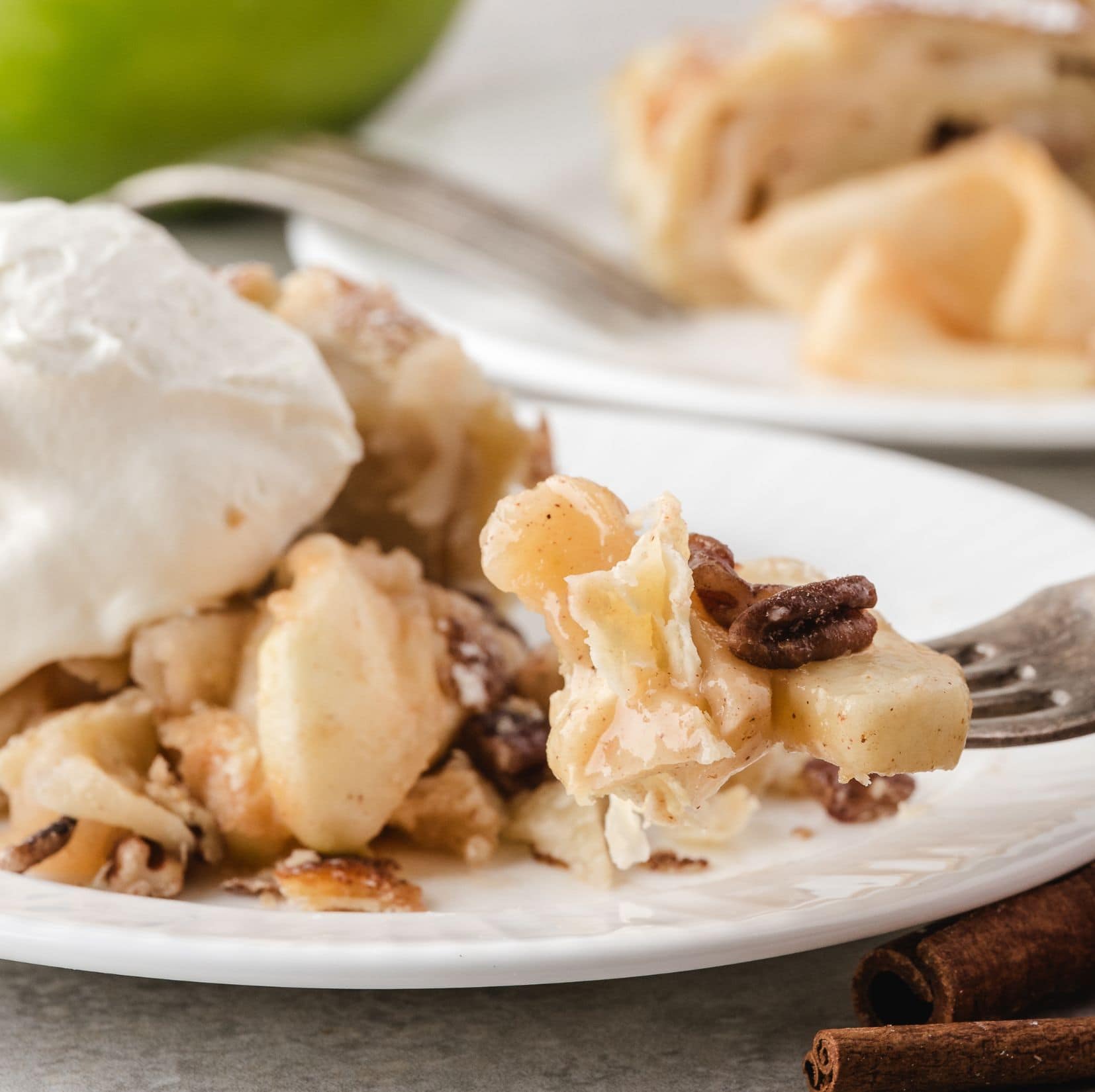 Apple strudel with puff pastry on a serving plate with a fork and vaniila ice cream