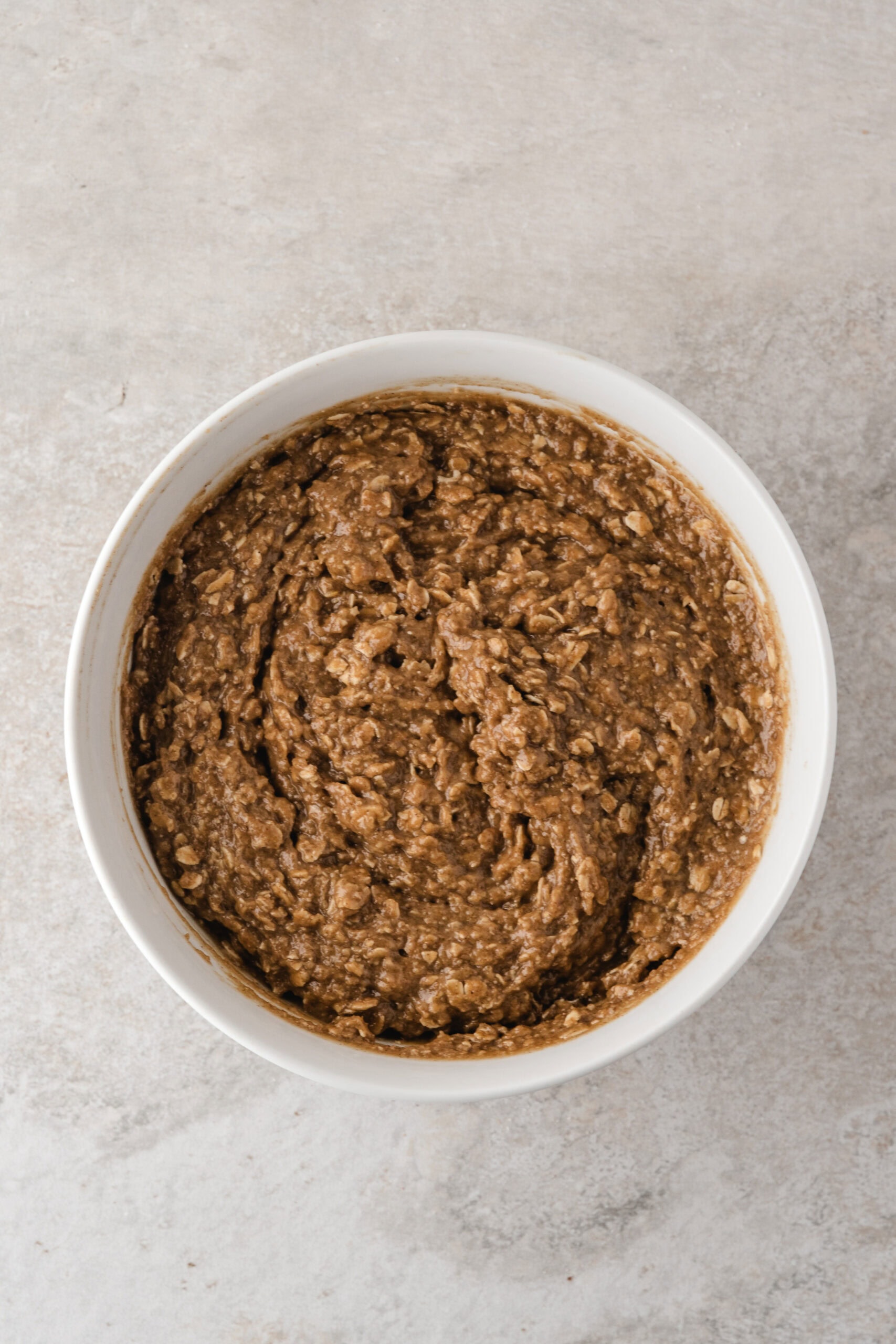 easy apple crisp prepared all mixed up in a bowl ready to be pressed down into the prepared baking dish to create