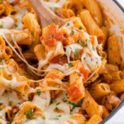 one pot chicken parmesan pasta with gooey cheese and a wooden spoon