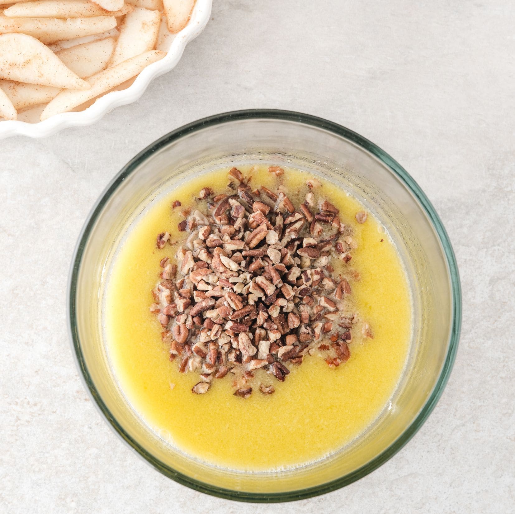 In a mixing bowl is shown melted butter with nut mixed in, ready to add the cake mix for the next step