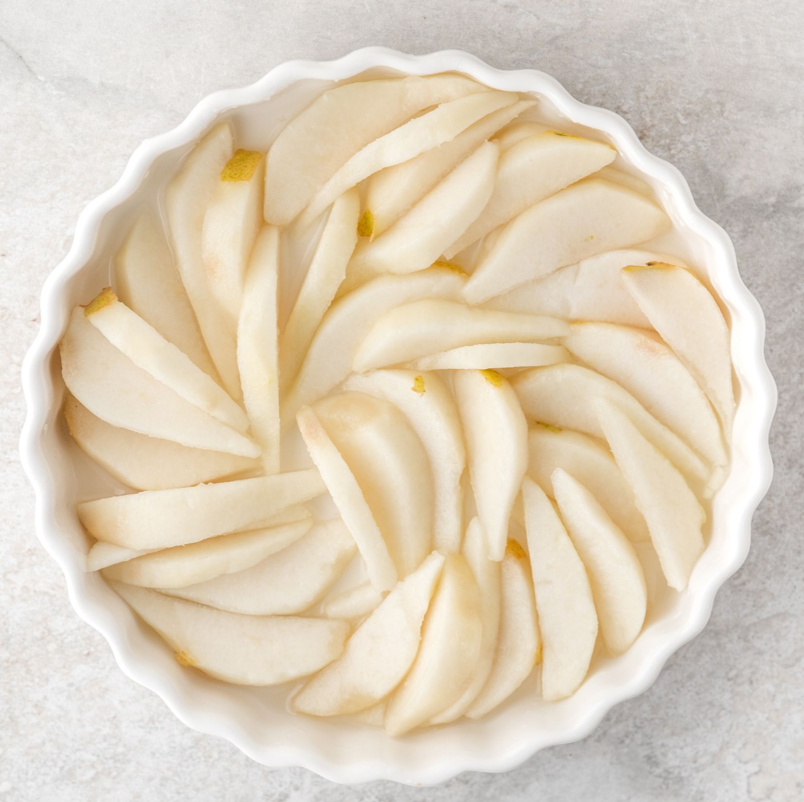 Fresh pears all cored and peeled, layered in the pie dish