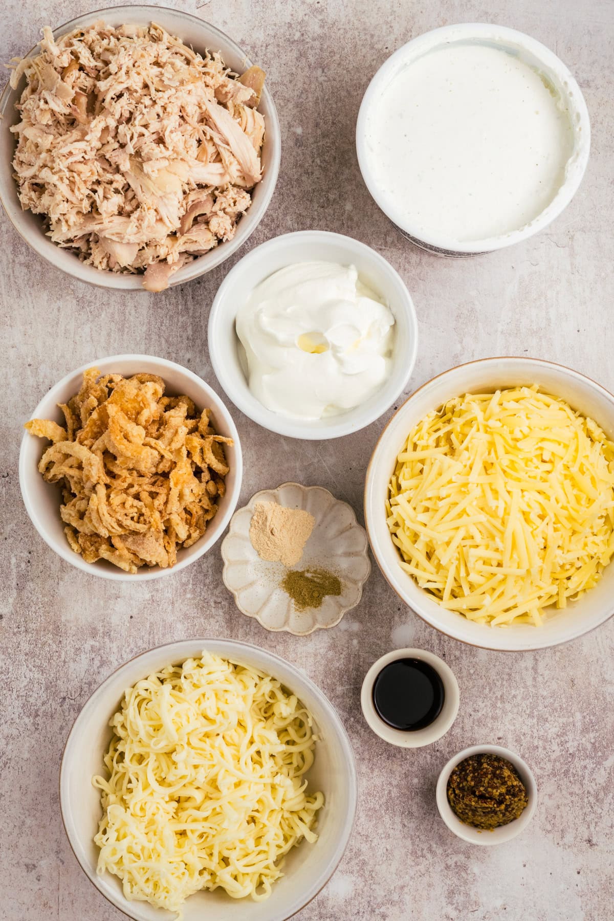 Ingredients pictured: cooked chicken, french onion dip, sour cream, dijon mustard, Worcestershire sauce, garlic powder, thyme, friend onions, Gruyere & Mozzerella cheese