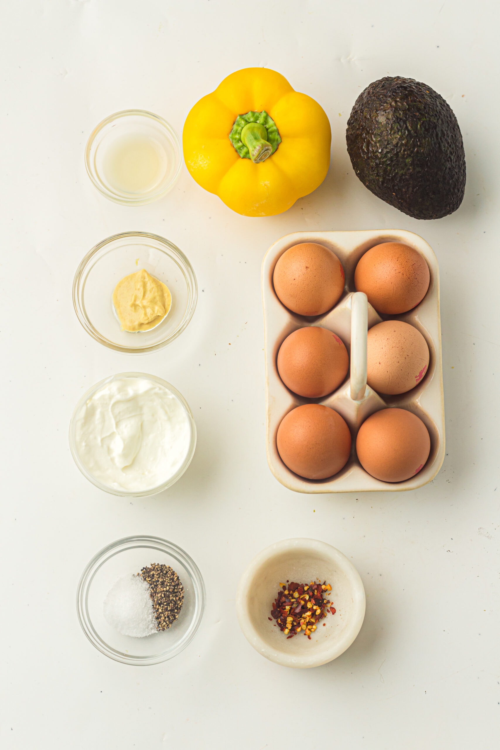 All ingredients picture to create the recipe of Christmas Tree Deviled eggs: eggs, mayo, crushed pepper, salt, pepper, dijon mustard, lemon juice, avocado, yellow pepper