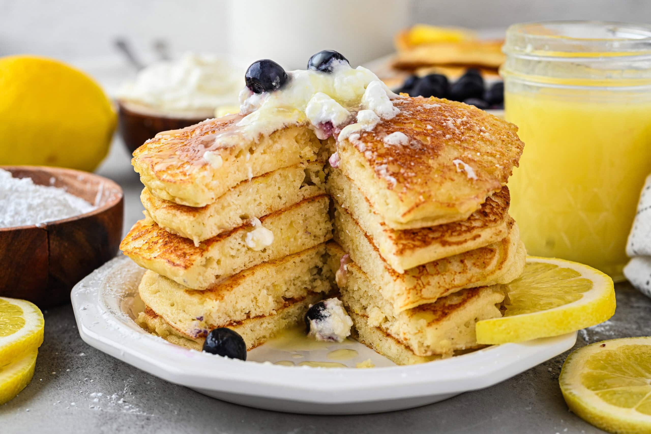 A stack of lemon ricotta pancakes on a plate ready to be served.