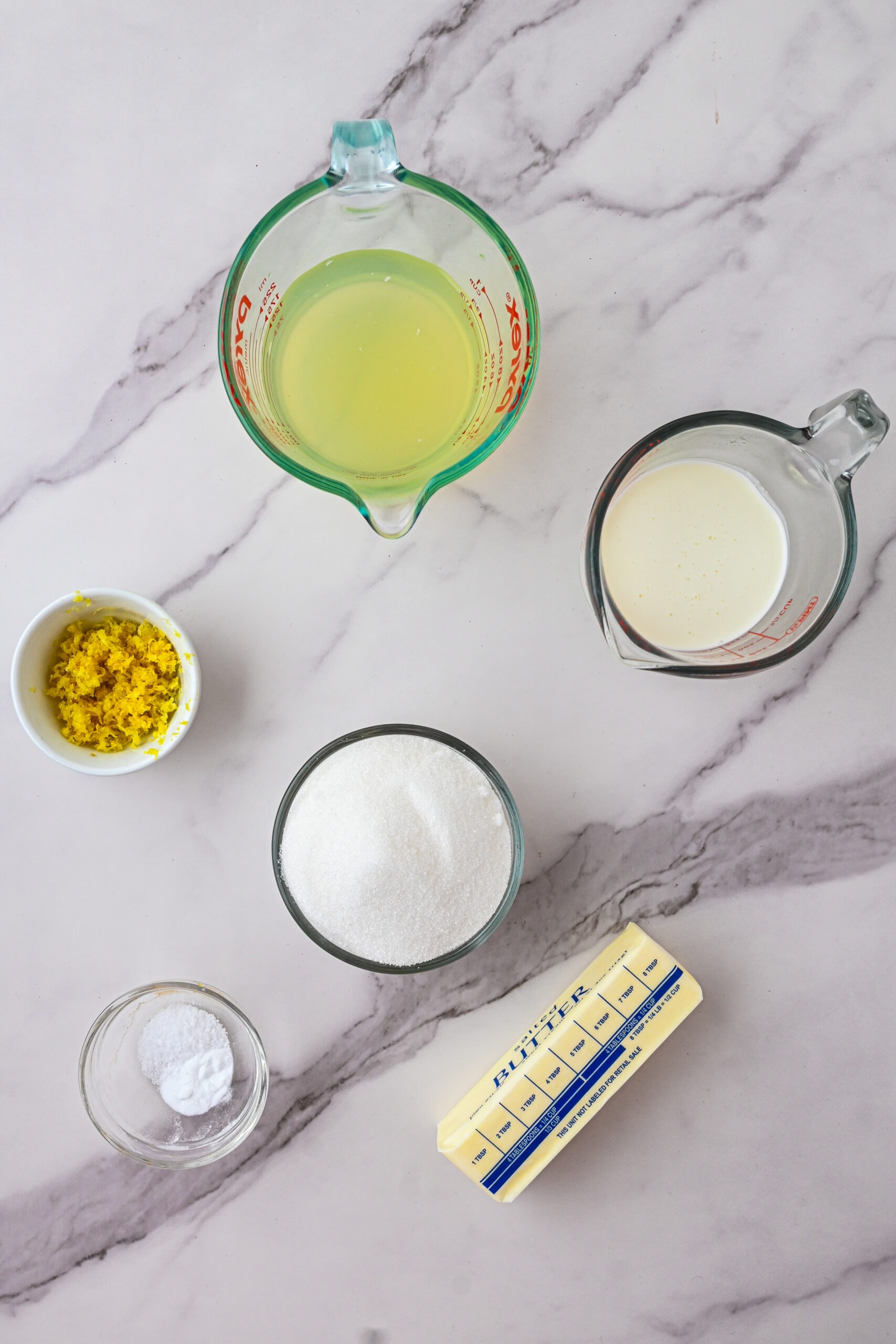 All ingredients pictured to create Lemon Syrup: butter, baking soda, lemon juice, lemon zest, sugar and milk