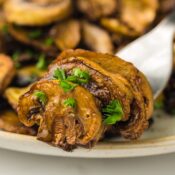 three air fried mushrooms on a fork