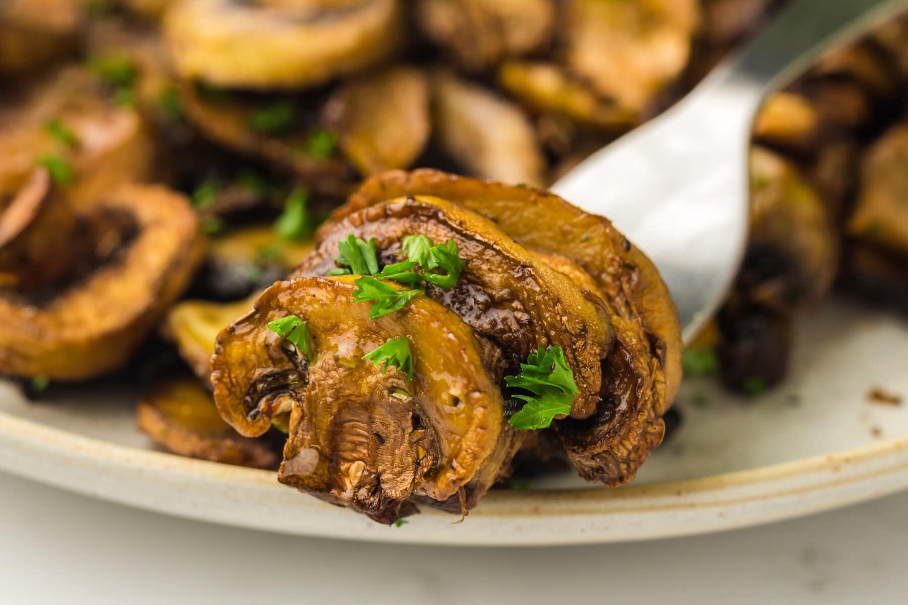 three air fried mushrooms on a fork