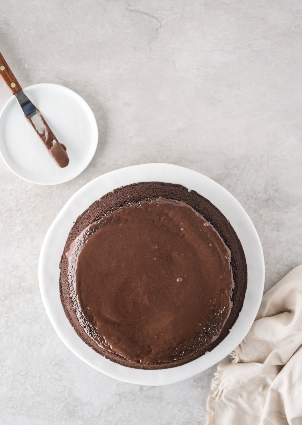 Chocolate sauce has been poured onto chocolate turtle cake and evenly placed