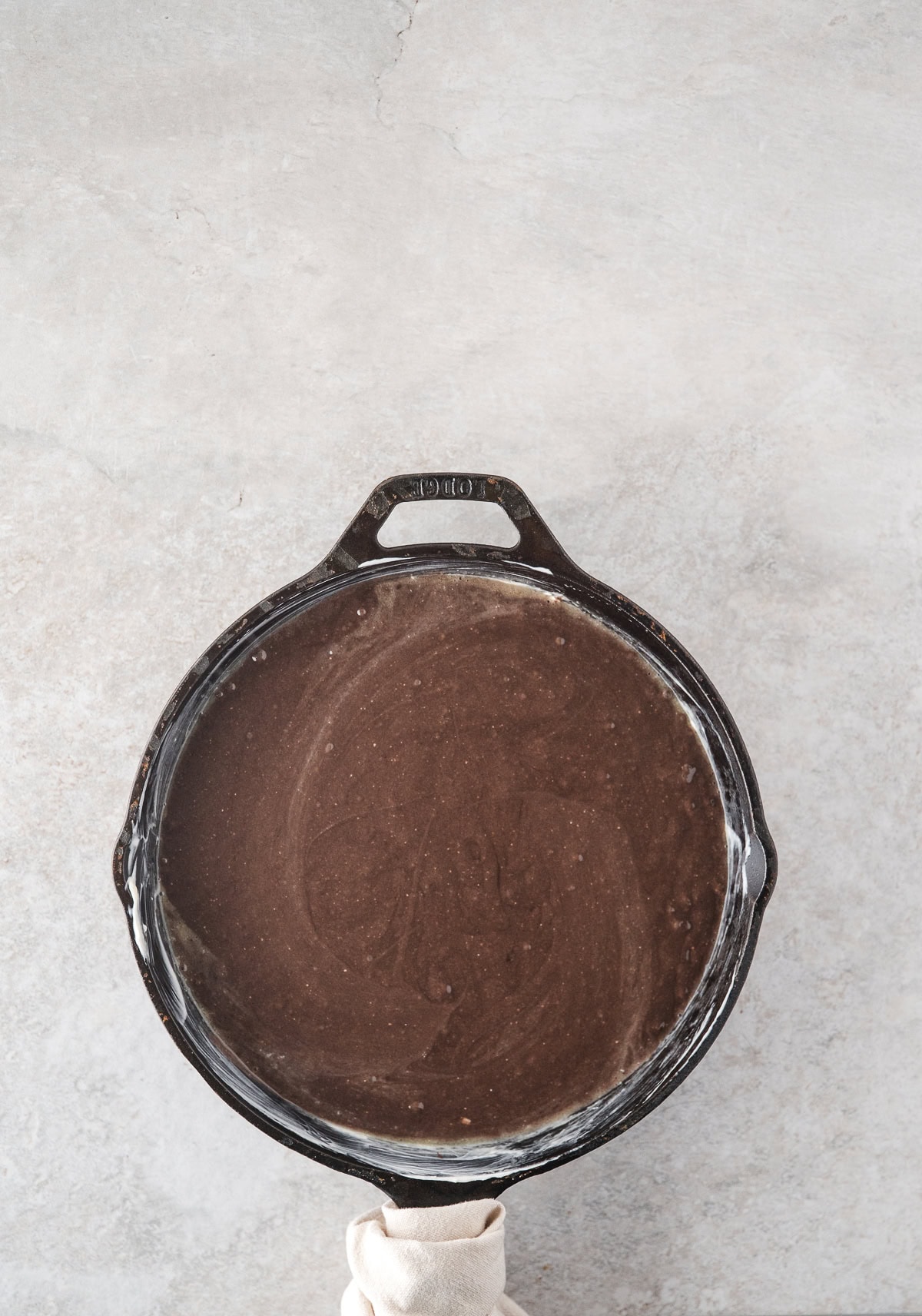 Cake mix in a skillet pan to be baked to create chocolate turtle cake
