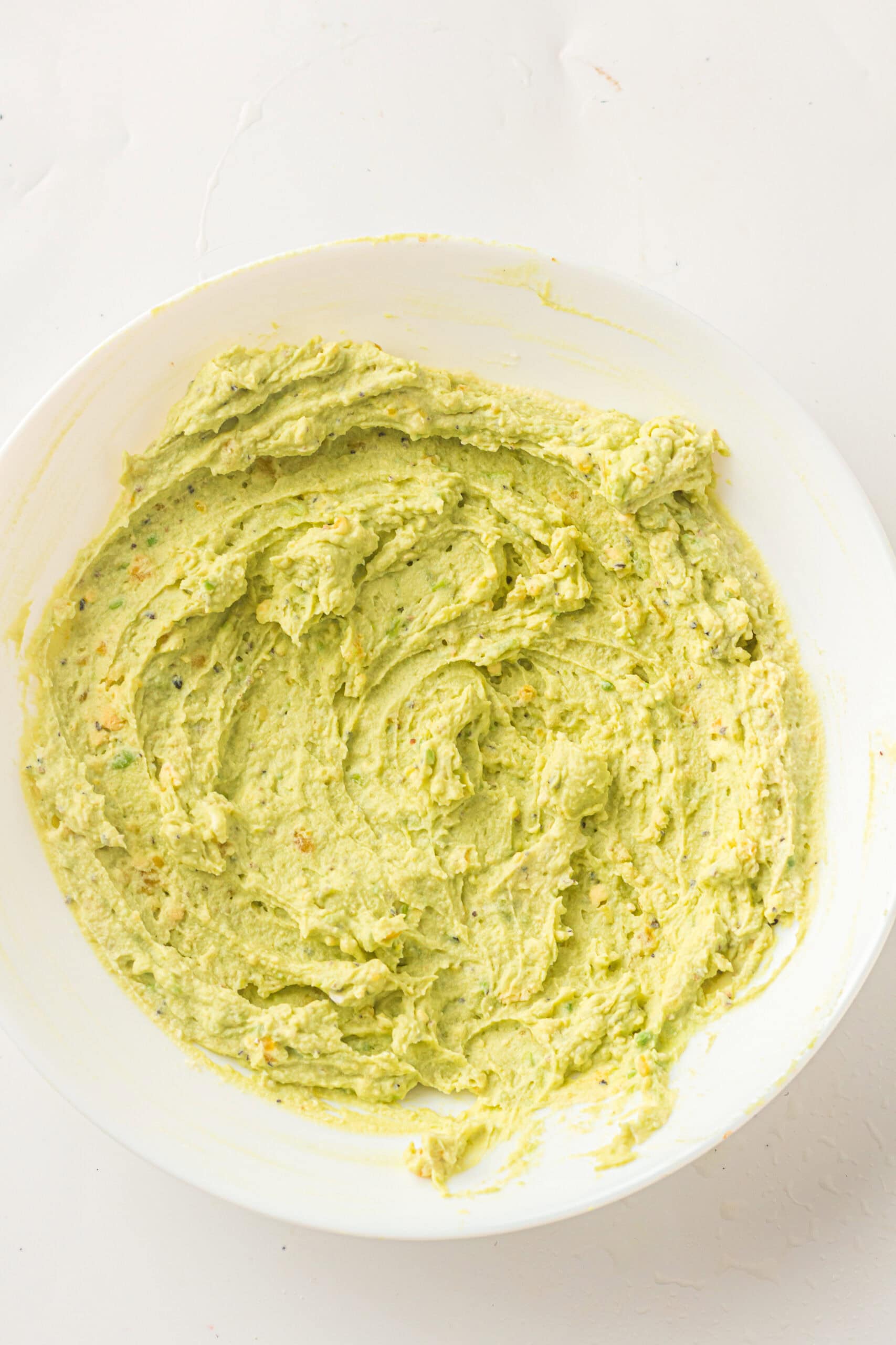 Mixing all the ingredients to create the deviled eggs: avocado, mayo, lemon juice, salt and pepper