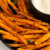 Crispy Air Fryer Sweet Potato Fries all served up with garnish and dip