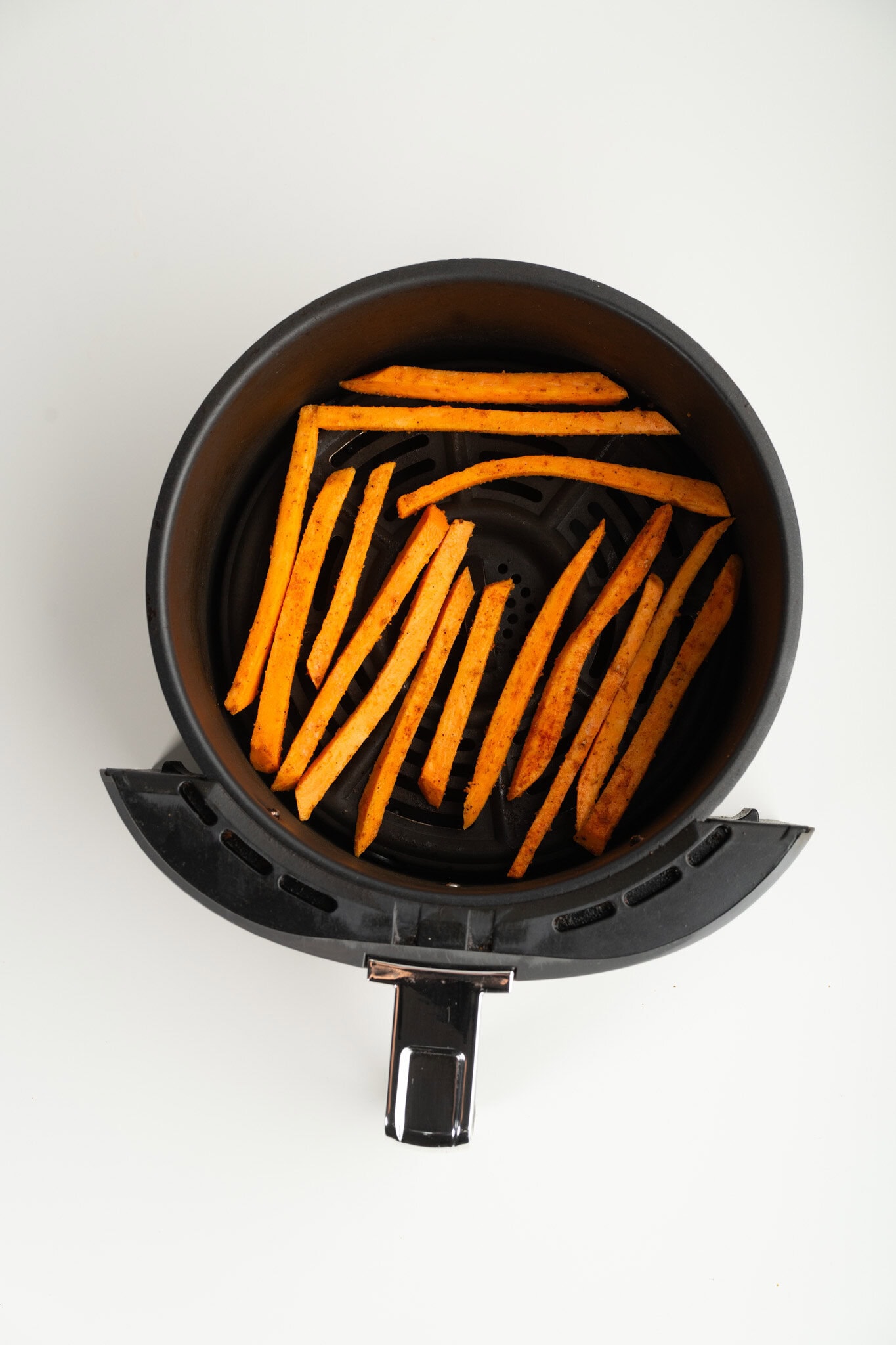 Sweet Potato Fries are placed in air fryer basket, space in between each fry