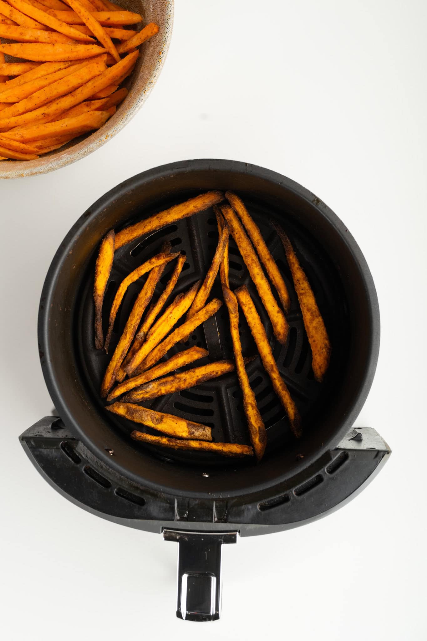 Sweet Potato Fries are all cooked in the air fryer basket ready to be cooled and enjoyed