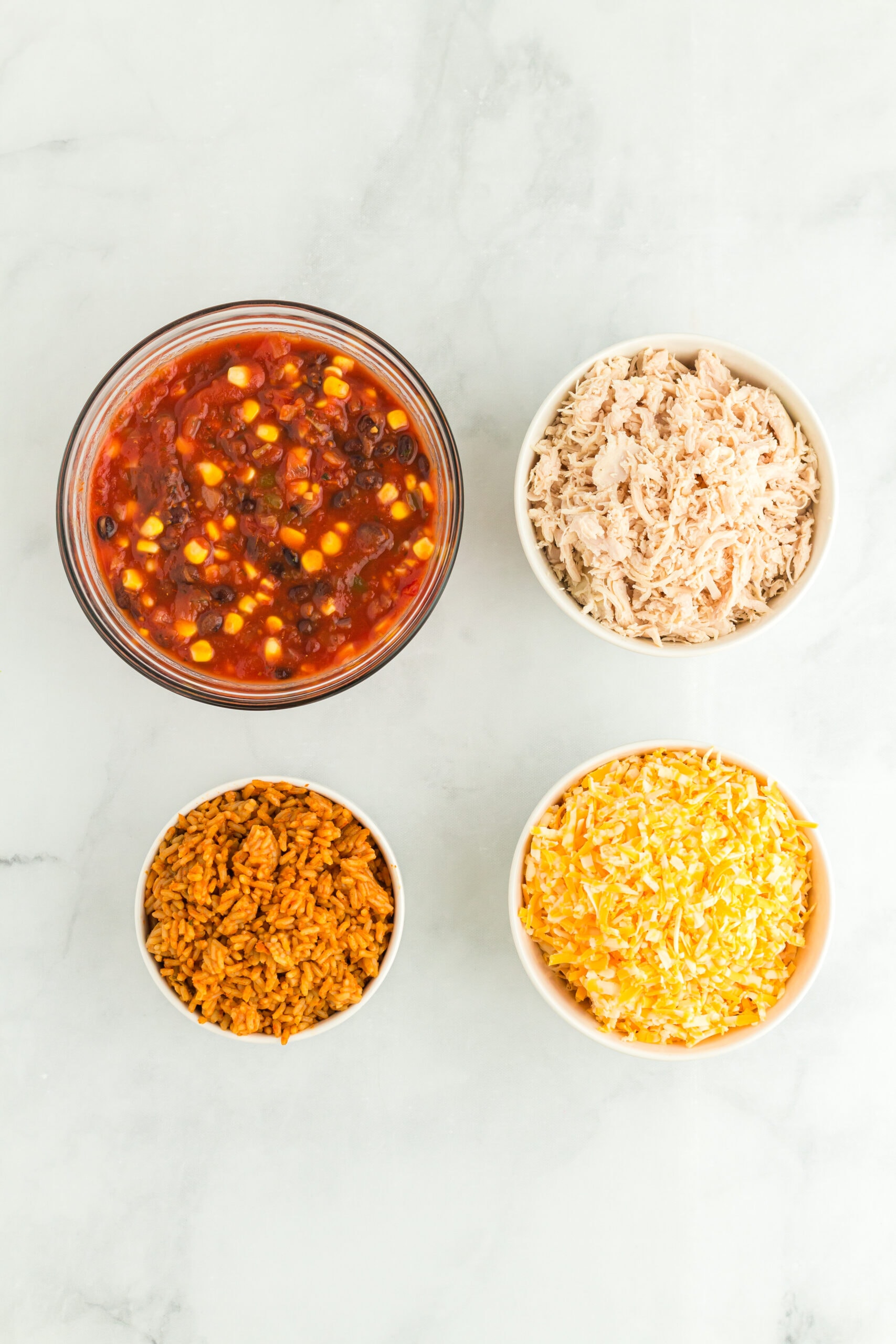 All ingredients pictured : cooked chicken breast, can of black beans and corn salsa, ready made Mexican rice, cheddar cheese