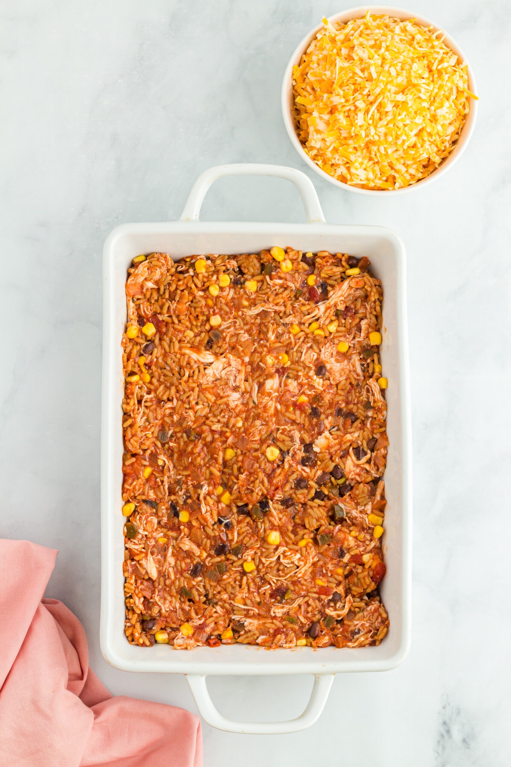 Can of black beans with corn and added chicken in a 9x13 baking dish