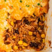 A scoop is taken out of the Mexican Chicken Rice casserole to show all the layers