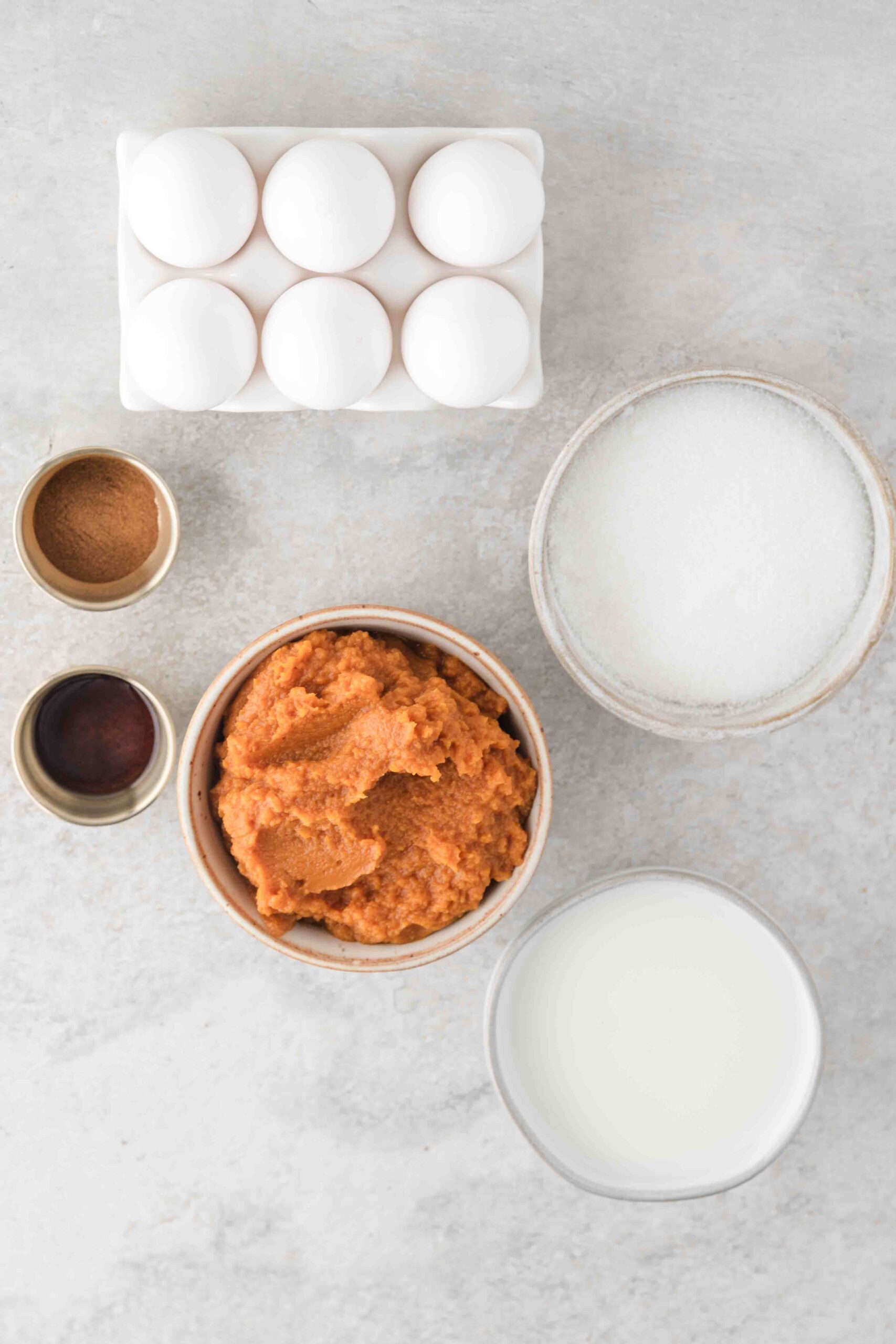 Ingredients to make a pumpkin flan: eggs, pumpkin, sugar, milk, vanilla bean paste, cinnamon