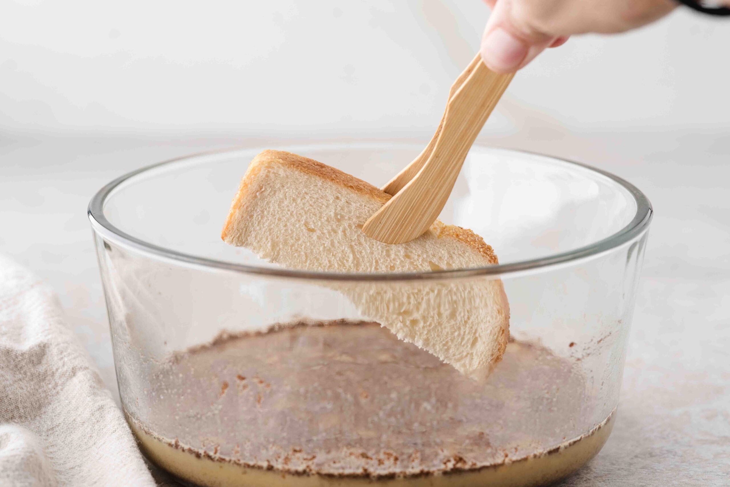 Bread slice getting ready to be dipped in cinnamon batter