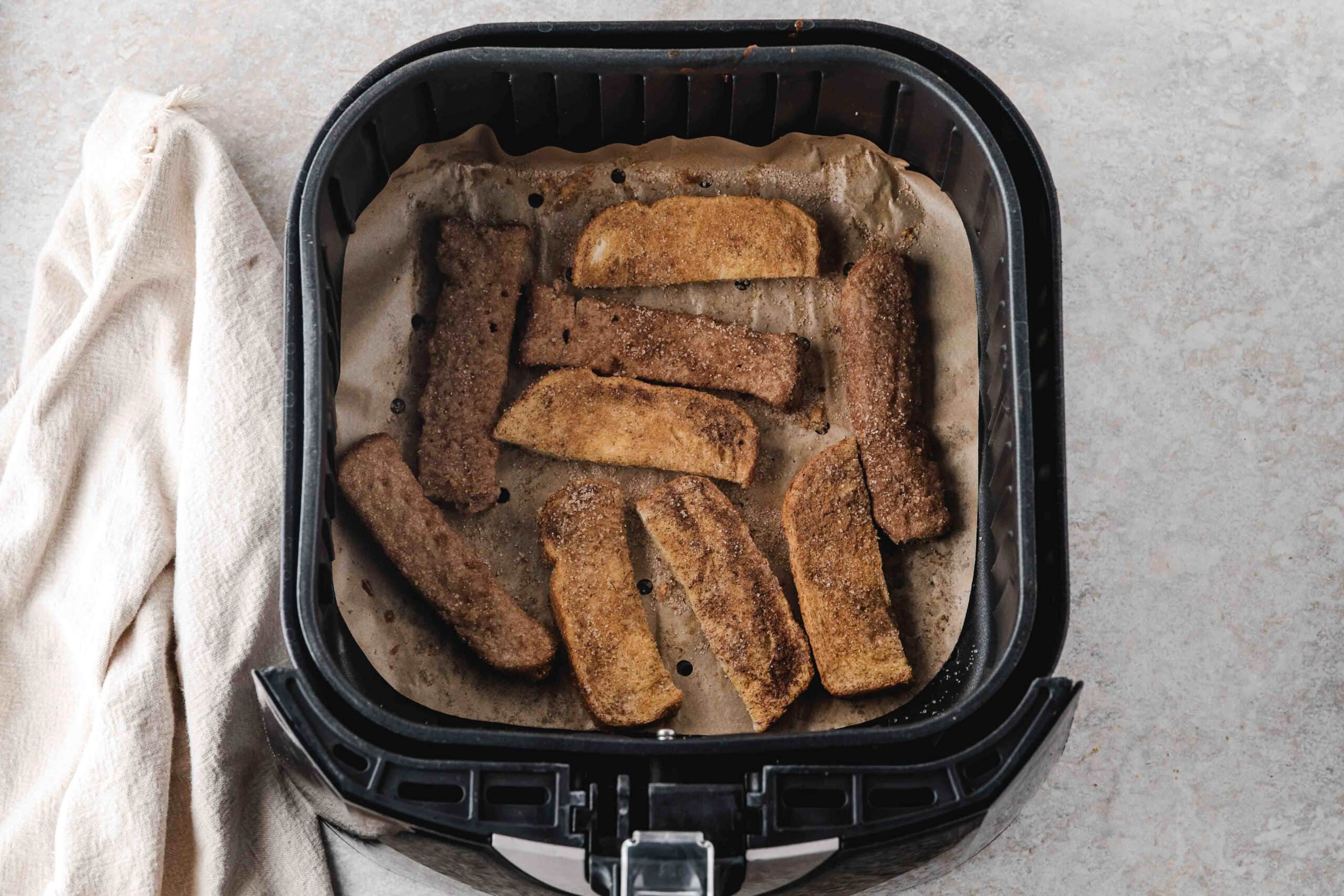 Air Fryer french toast sticks in air fryer all ready to be cooled and plated