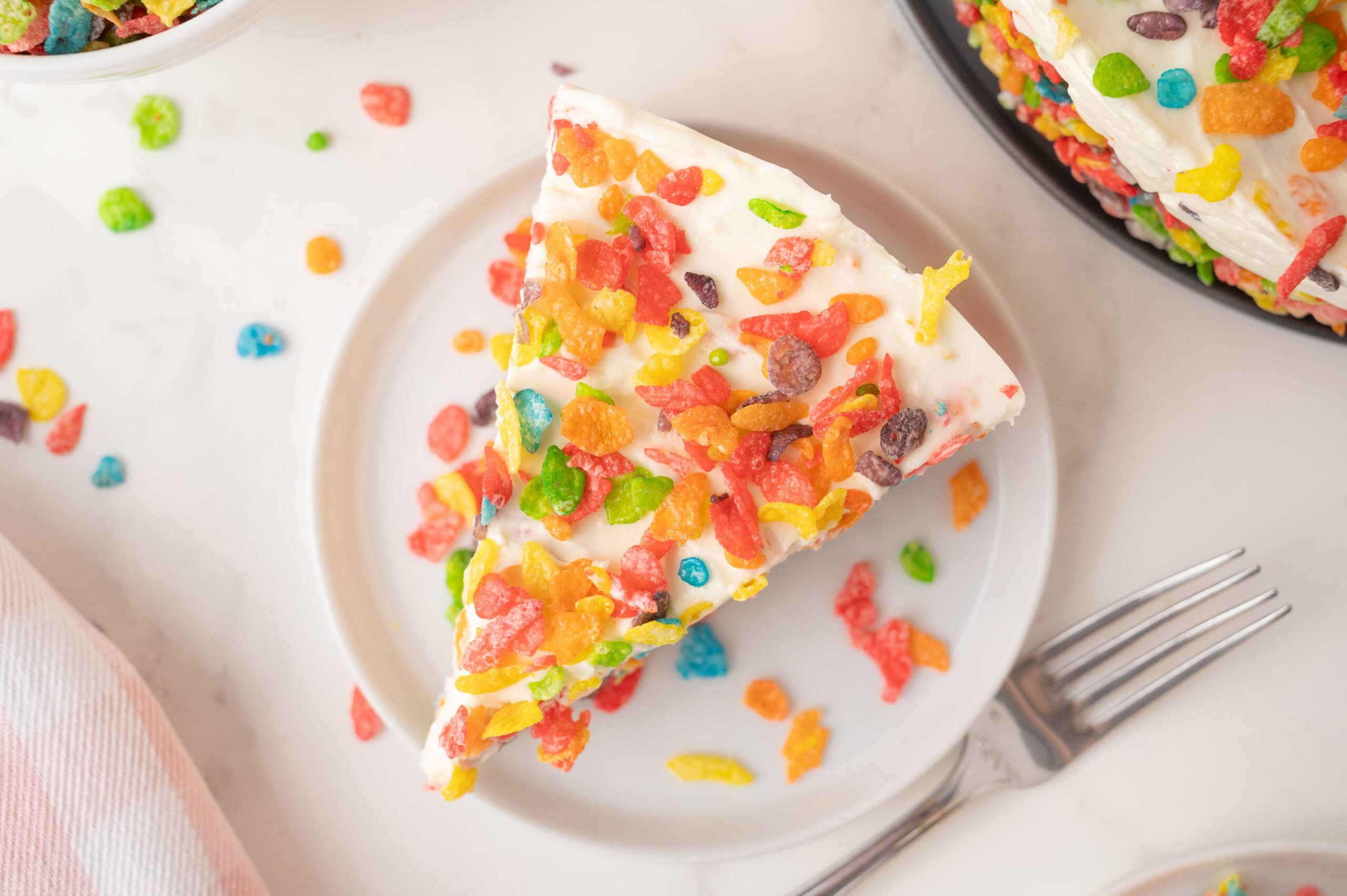 Fruity Pebble Cheesecake all plated with a fork ready to be eaten