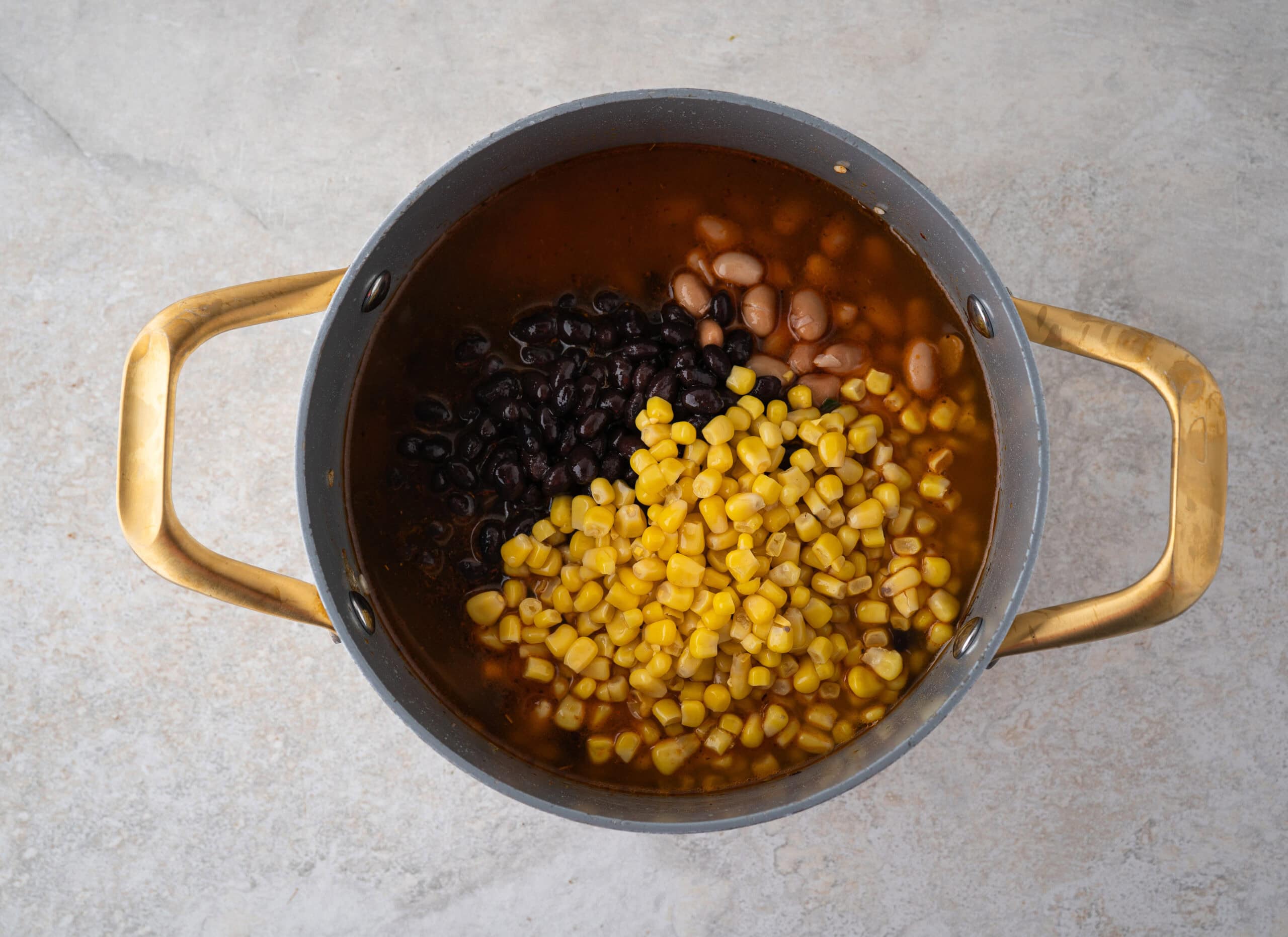 Process of adding corn and beans to broth