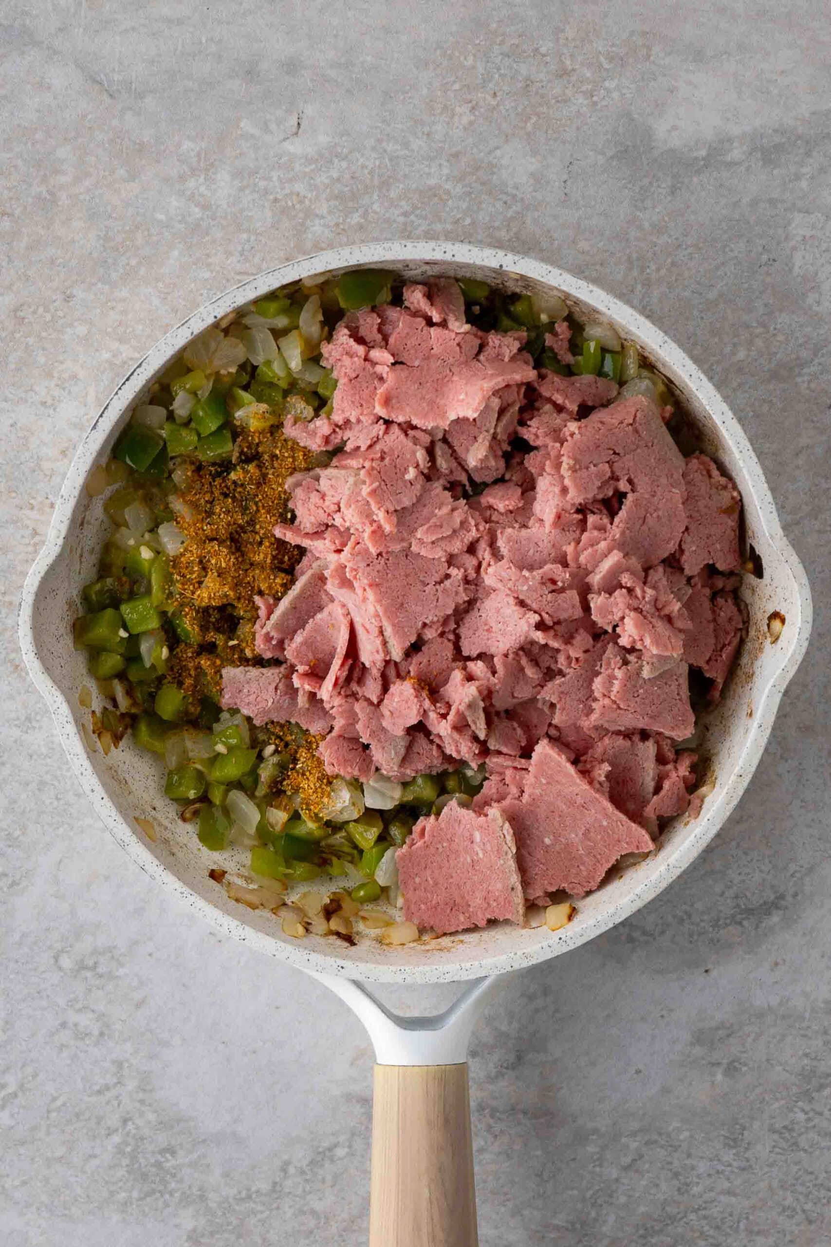 Steak slices add to the saute pan with green peppers, onion and spices