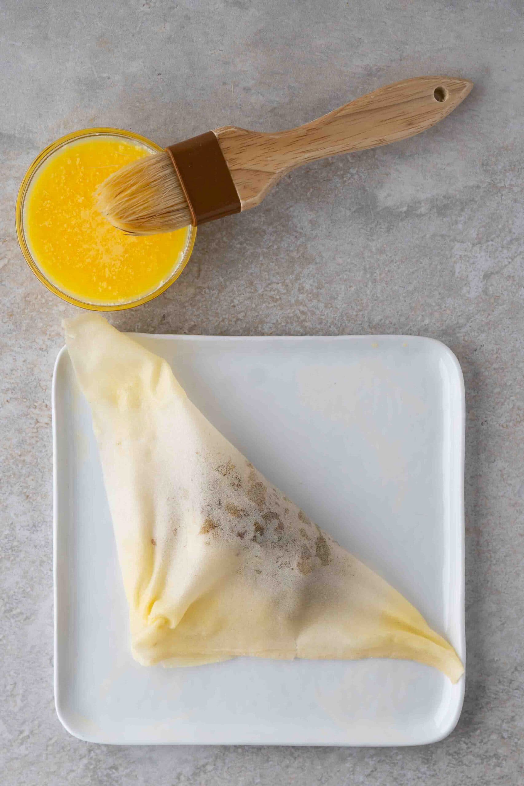 Folding the cheese steak roll and sealing with an egg wash