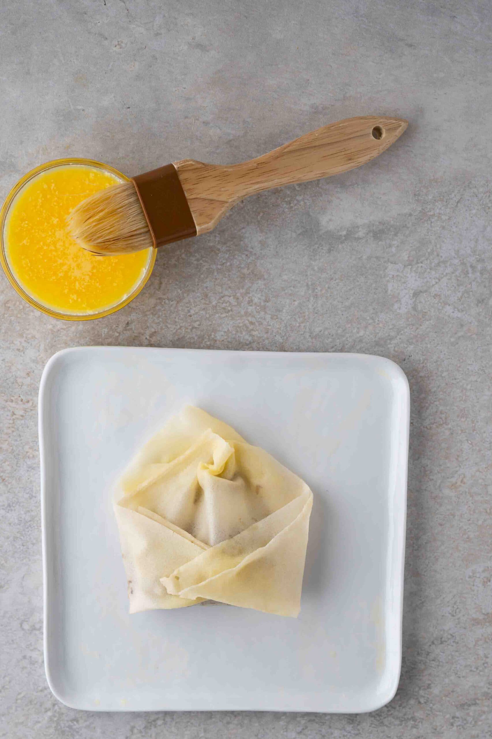 Egg wash over the philly cheese steak egg roll to finish the process of creating the egg rolls