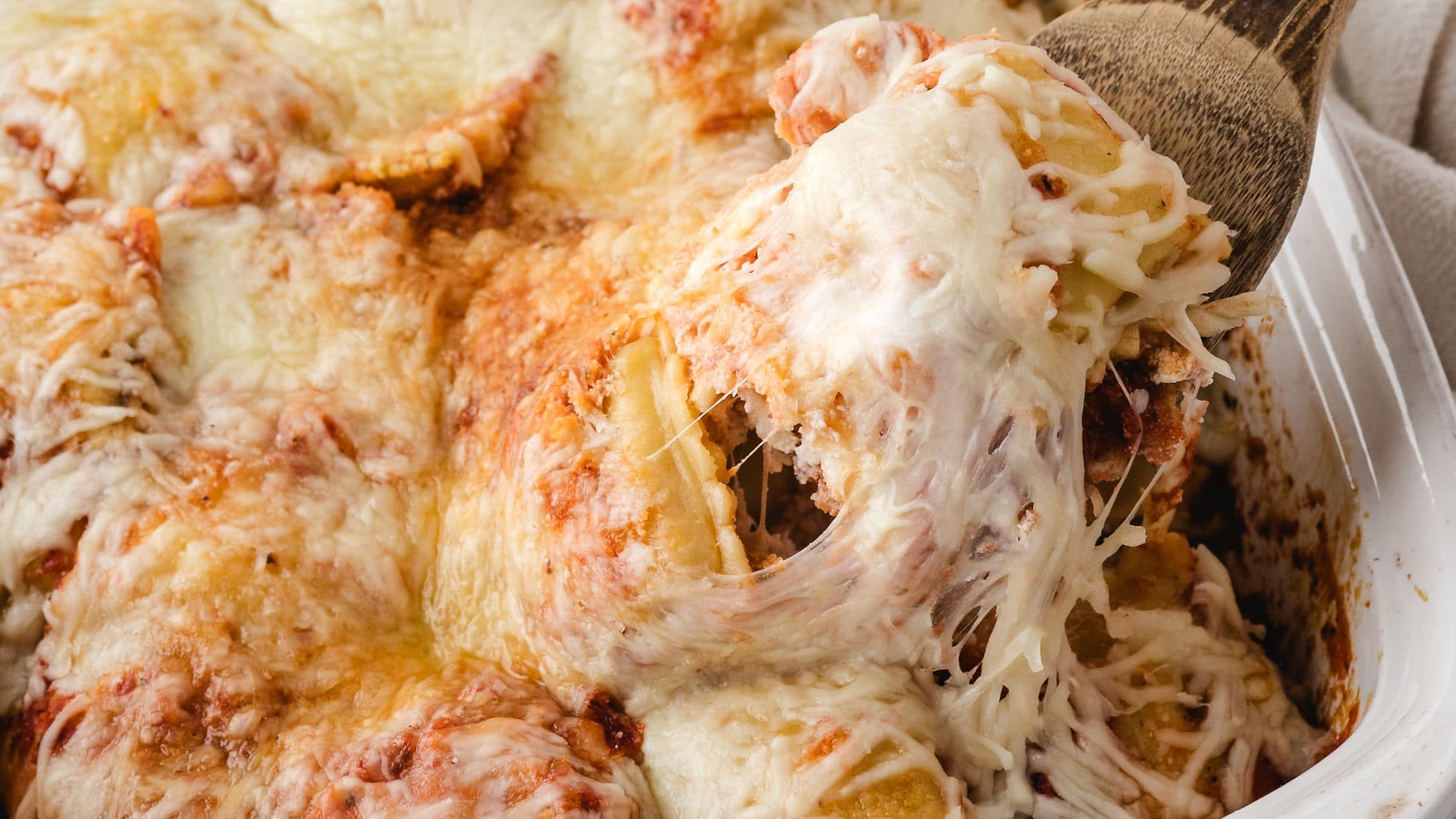 Cheesy Baked Ravioli scooped up, ready to be served onto a plate