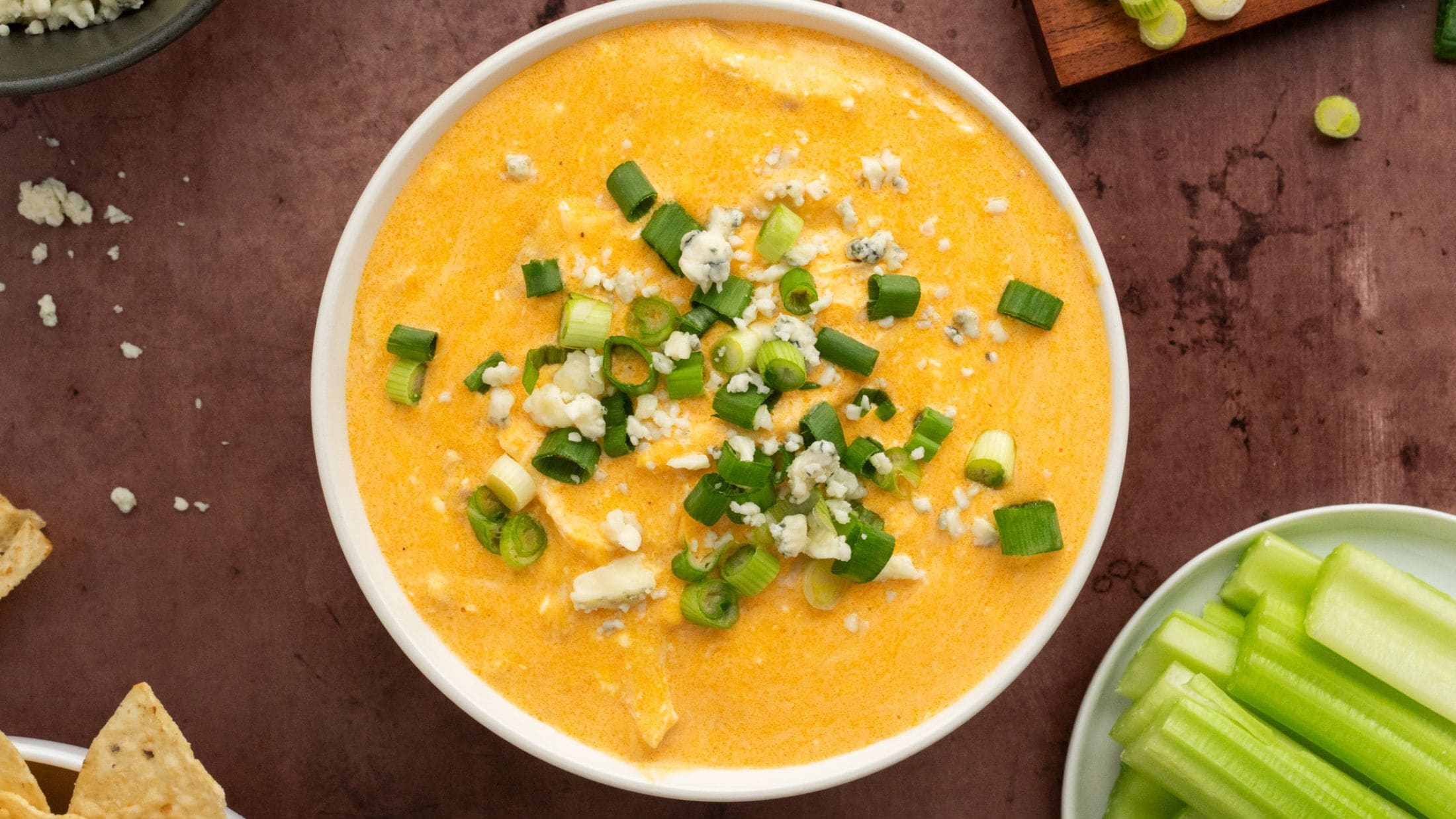 Buffalo chicken dip made in the instant pot is cooled down & served in a bowl, with celery and tortilla chips, ready to be enjoyed