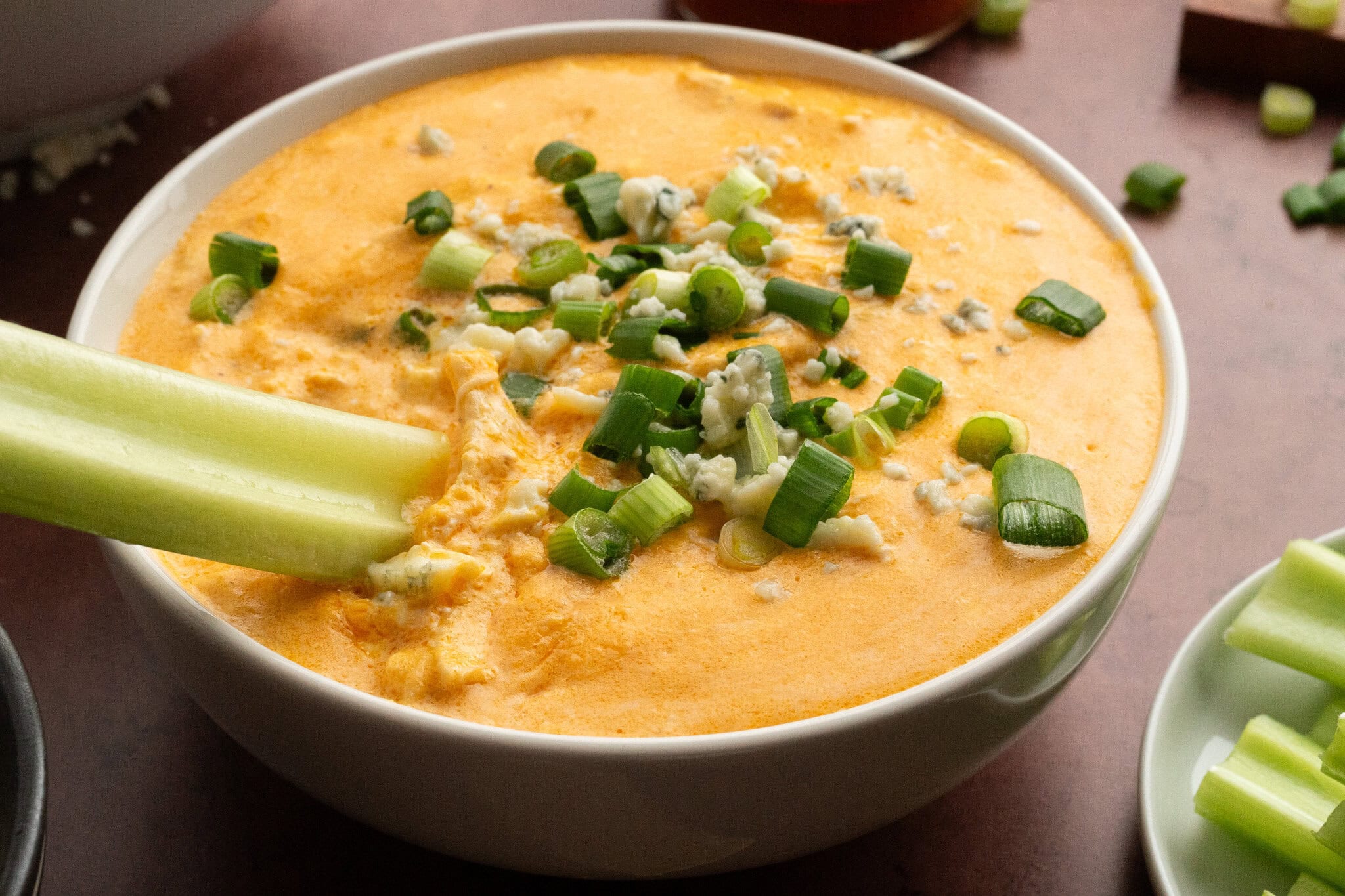 A bowl of buffalo chicken dip served with celery