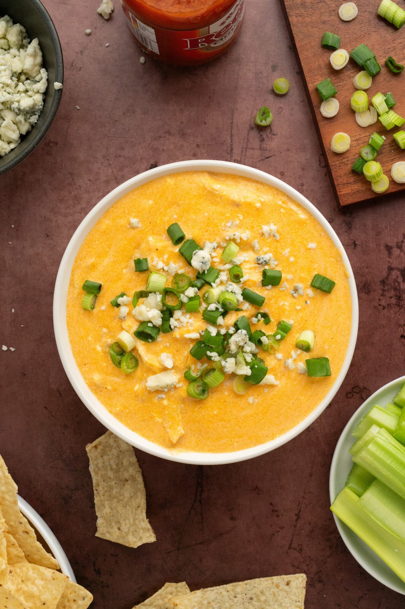 Buffalo chicken dip cooked and served in a bowl, garnished and served with tortilla chips and celery