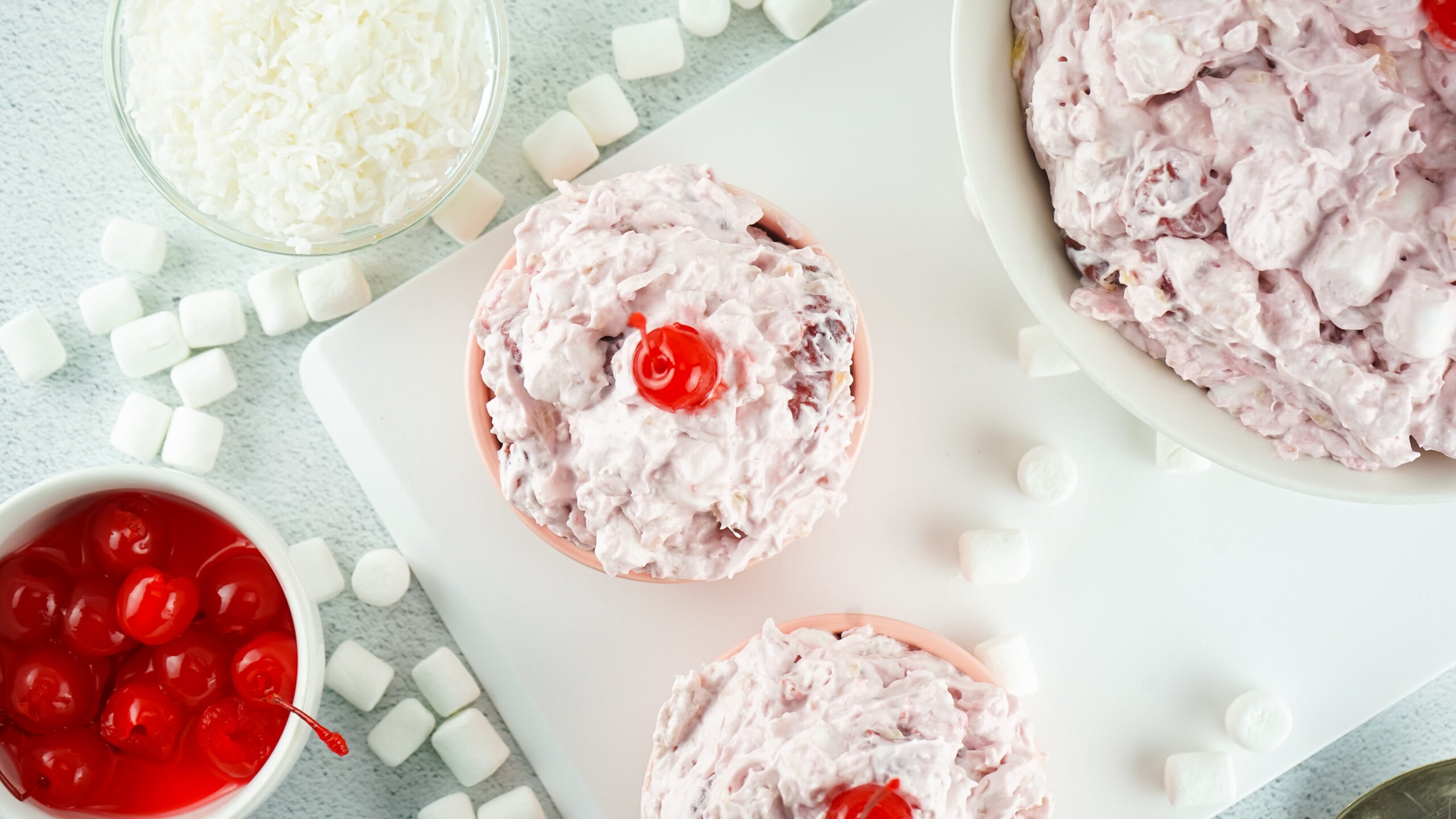 Cherry Fluff in a bowl, then served in two bowls next to it, ready to be enjoyed