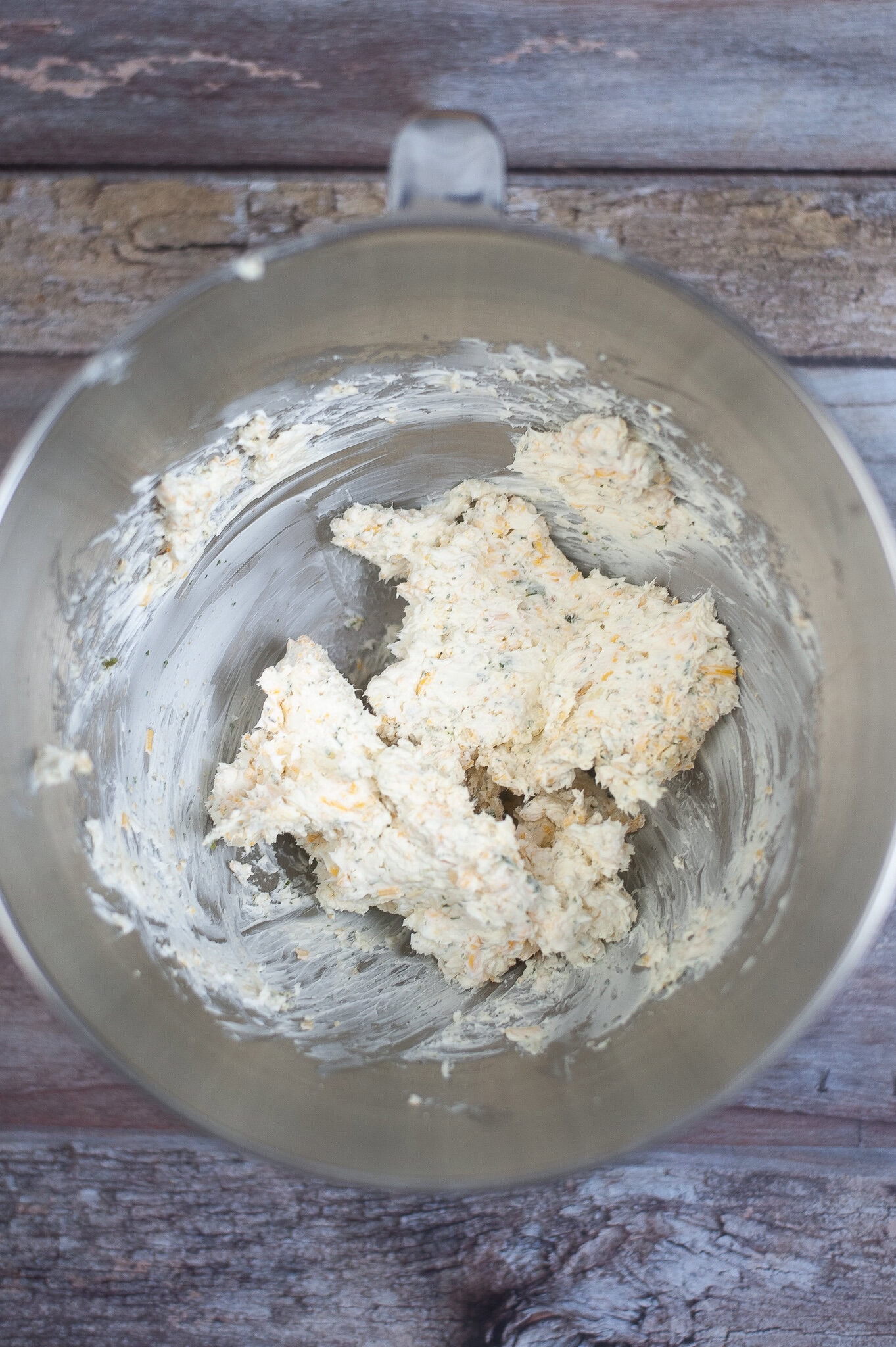 Mixing of cream cheese and cheddar cheese in a bowl