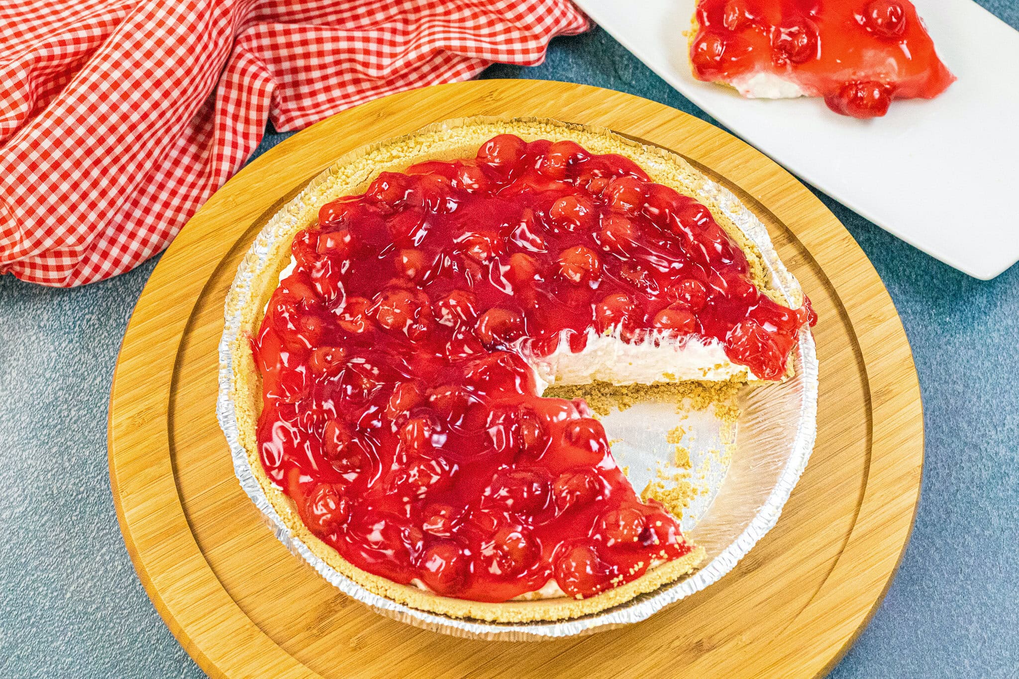 A slice taken out of the no bake cherry cheesecake to show the layers