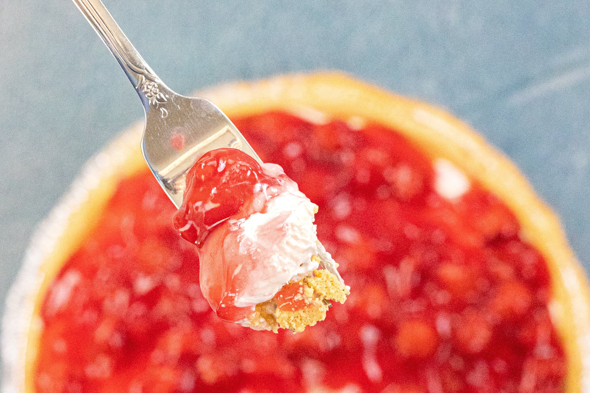 A close up photo, showing the the layers of the cherry cheesecake on a fork